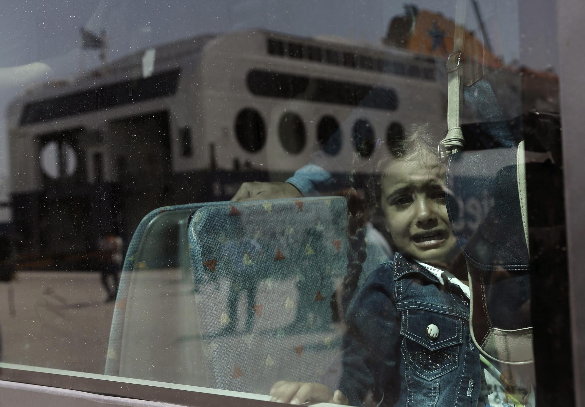  Una niña siria llora en un autobús tras desembarcar del ferry Eleftherios Venizelos en el puerto del Pireo en Grecia el 8 de septiembre de 2015. 