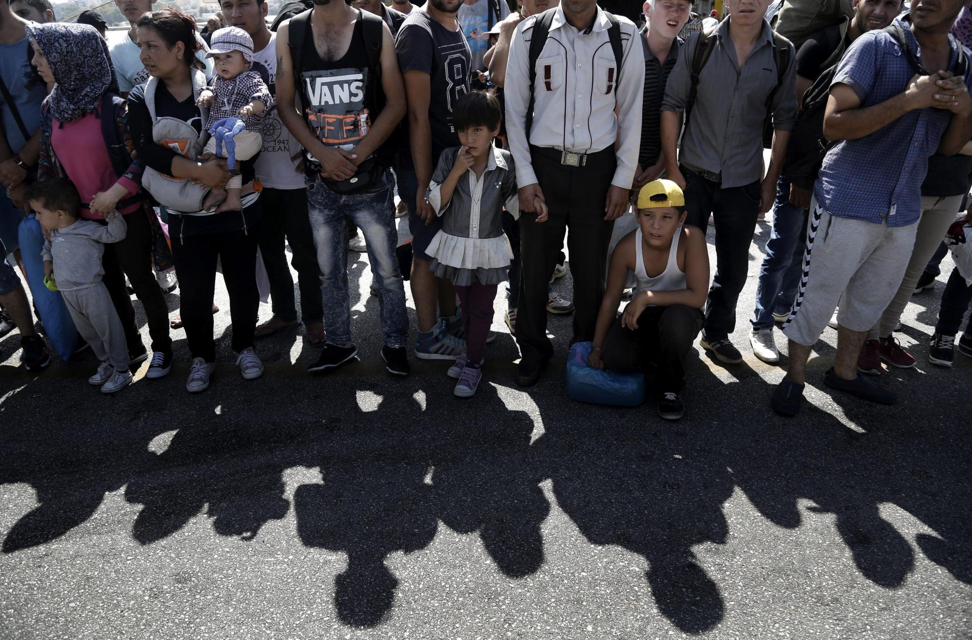 Refugiados, en su mayoría sirios, esperan para subir a un autobús tras desembarcar del ferry Eleftherios Venizelos en el puerto del Pireo en Grecia el 8 de septiembre de 2015. 