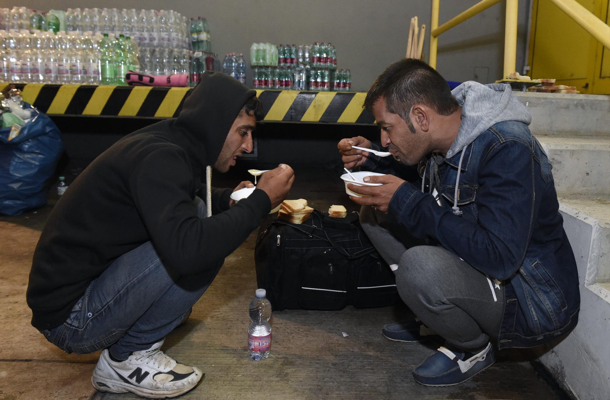 Dos hombres comen en uno de los lugares habilitados en Austria para recibir a los refugiados. 