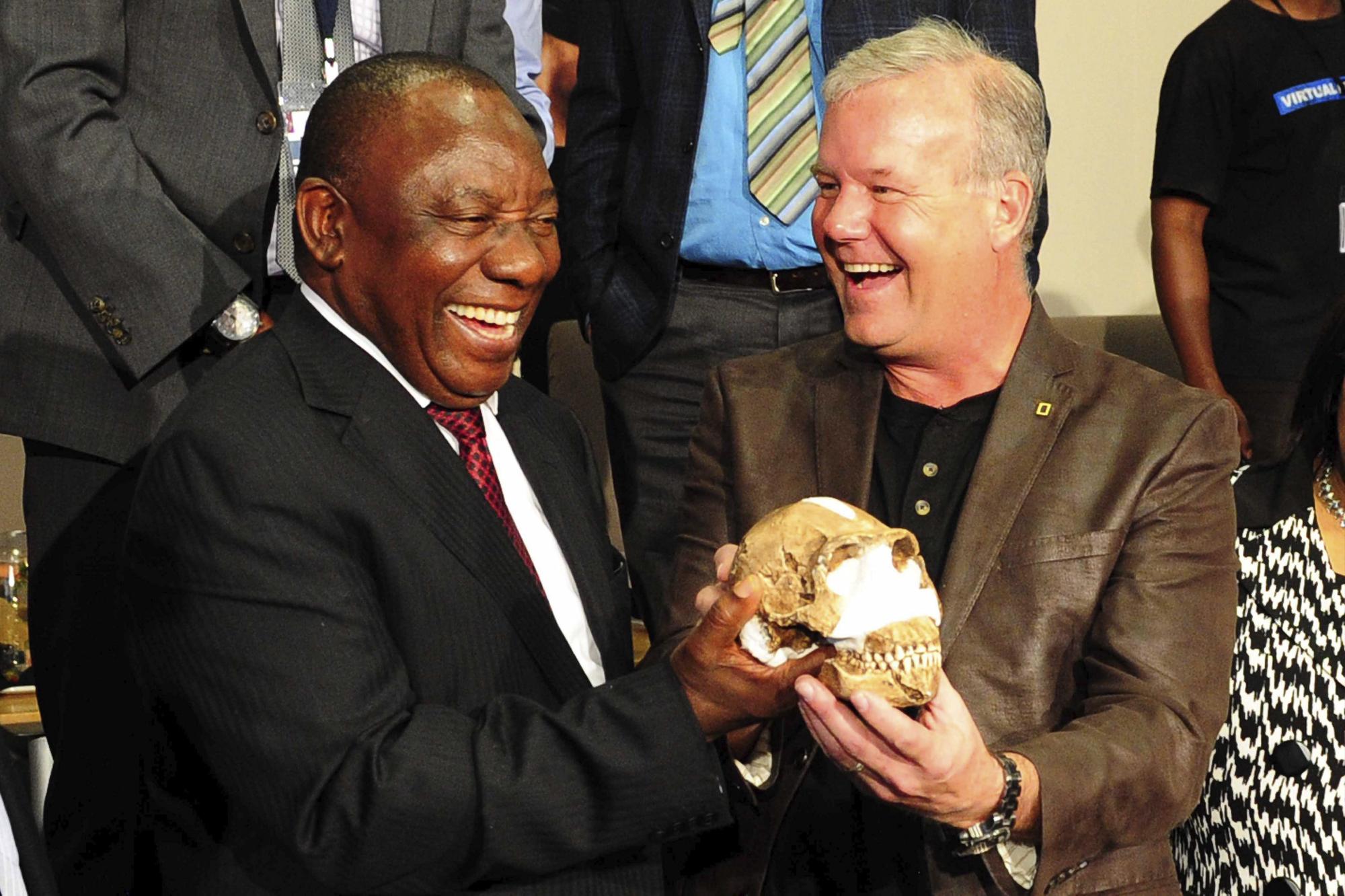 El profesor Lee Burger (derecha) de la Universidad de Witwatersrand y al vicepresidente sudafricano, Cryril Ramaphosa (izquierda), sostienen el cráneo del Homo Naledi durante su presentación en Johannesburgo.
