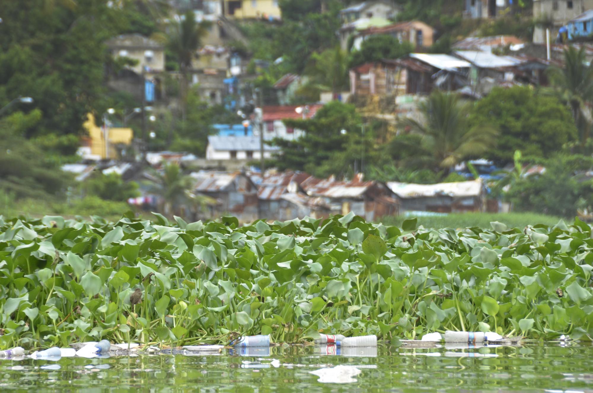 Basura sobre el río Ozama, al fondo el barrio Simón Bolívar.