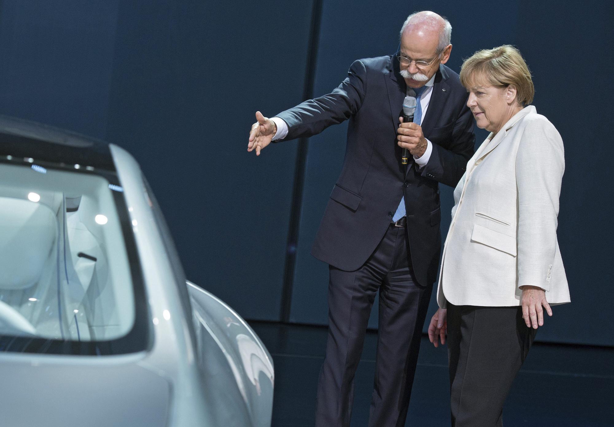 El presidente de Daimler, Dietcher Zetsche, y la canciller alemana, Angela Merkel (d), junto al prototipo Mercedes IAA. 