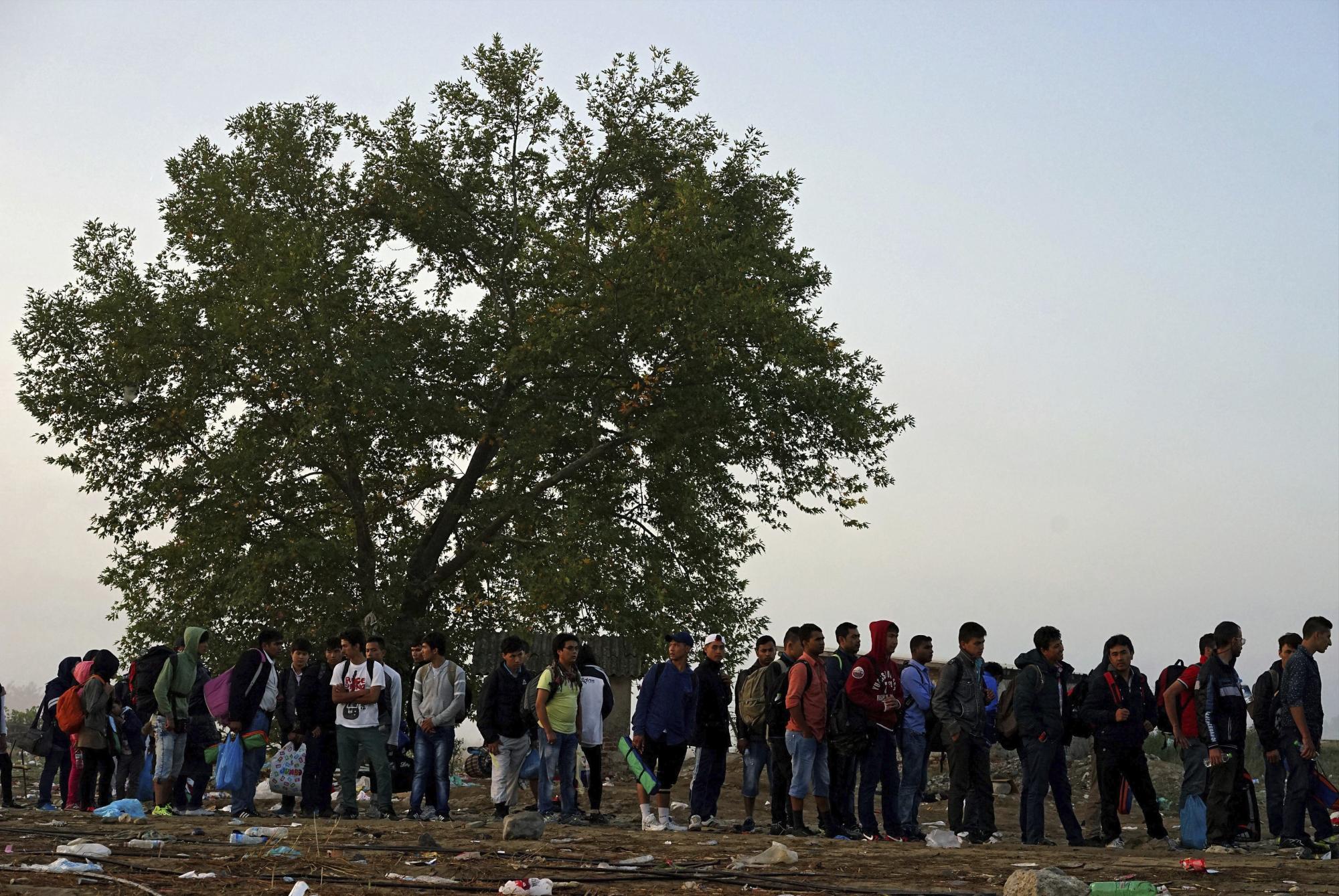 Refugiados esperan para entrar en un campamento de registro tras lograr cruzar a pie la frontera entre Macedonia y Grecia a la altura de Gevgelija (Macedonia), el 17 de septiembre de 2015.