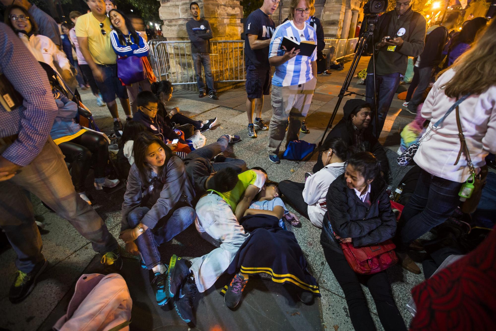 Varias personas esperan antes del amanecer para coger el mejor sitio desde donde ver al papa en su recorrido por la Avenida de la Constitución en Washington DC hoy, 23 de septiembre de 2015. 