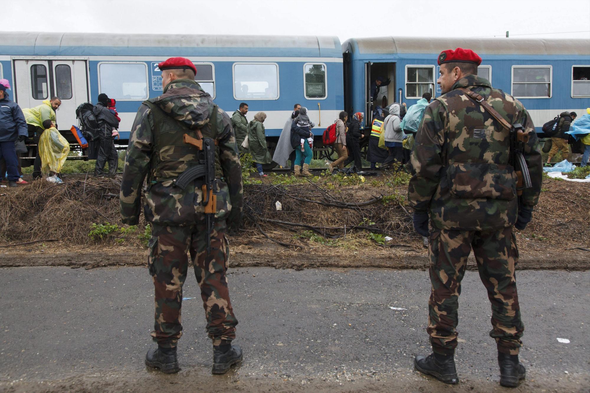 Agentes de policía controlan el acceso de los refugiados procedentes de Croacia al tren en Zakany, a 230 kilómetros de Budapest, Hungría. 