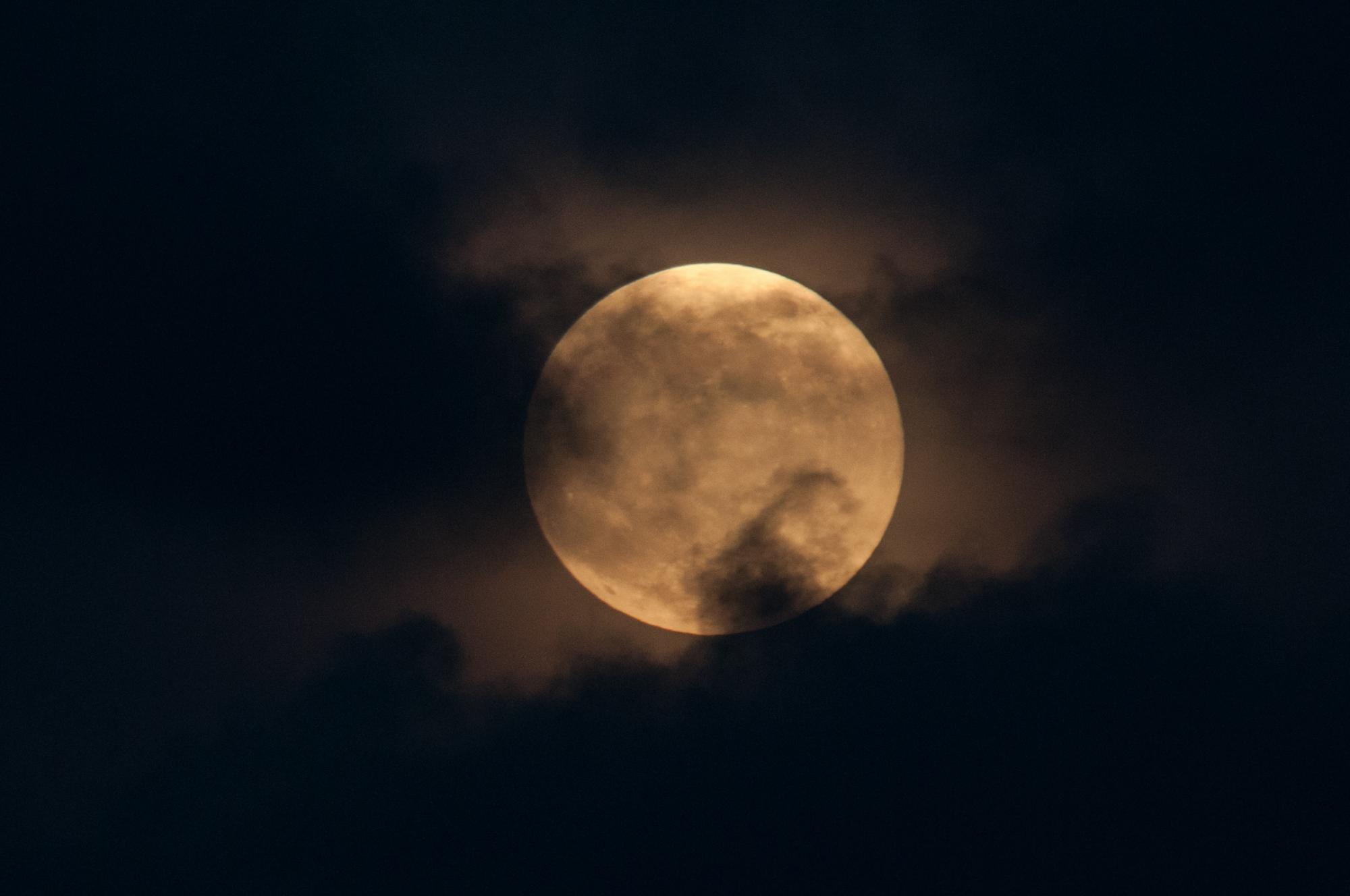 Algunas nubes cubren el disco lunar.