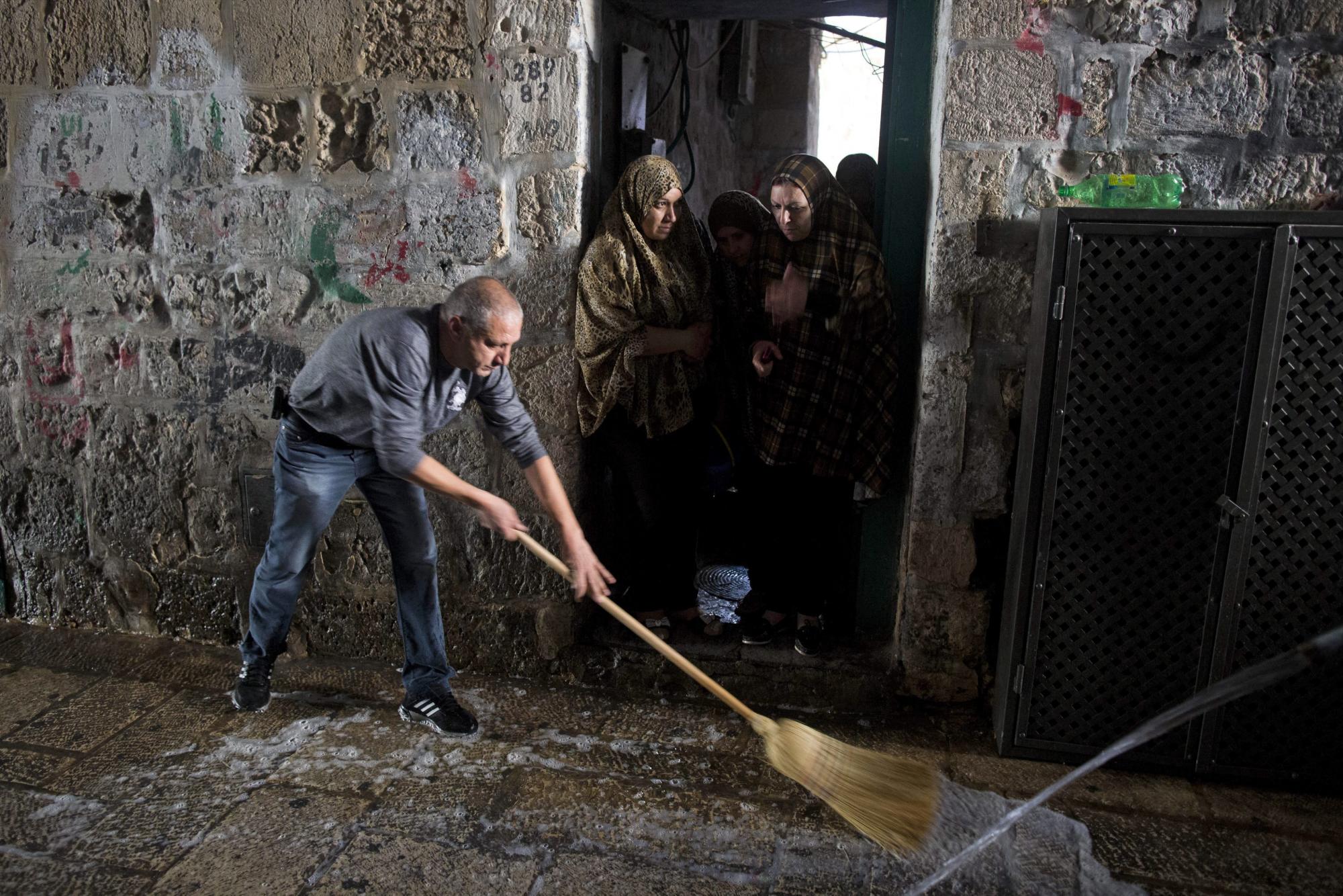 Un palestino limpia la escena del suceso tras un ataque en el que se vio implicada una mujer palestina y un israelí en el casco viejo de Jerusalén, Israel, hoy, 7 de octubre de 2015.