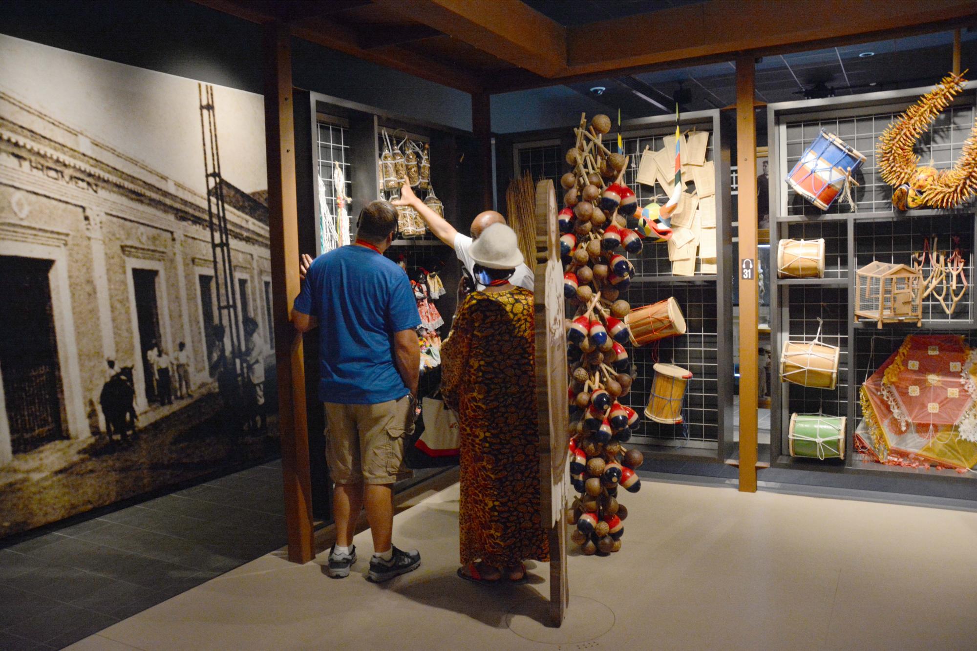 Fotografía cedida por el Centro León que muestra a turistas viendo las exposiciones sobre elementos típicos de Santiago.