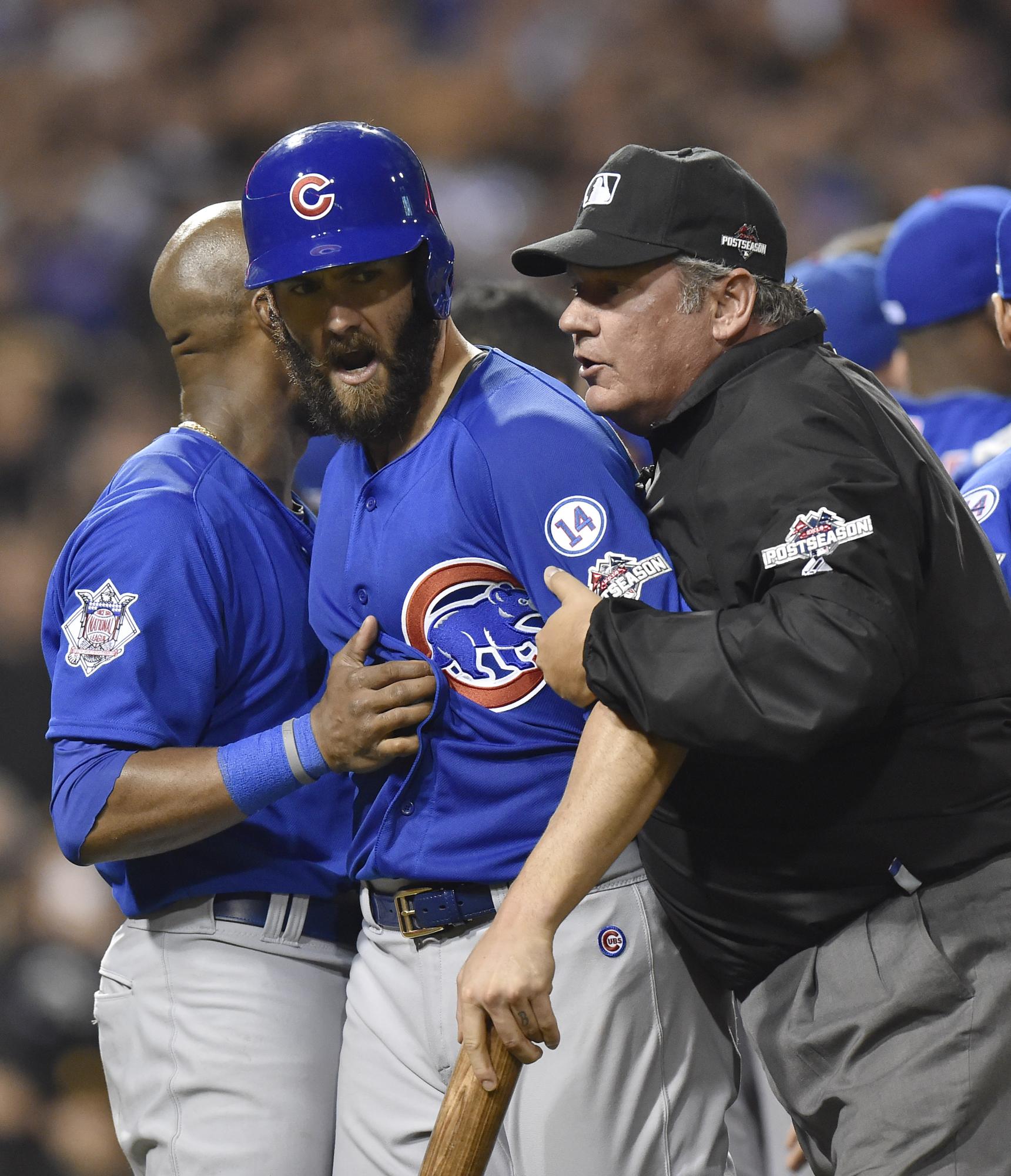 El pitcher Jake Arrieta de los Cachorros de Chicago es contenido por el umpire Hunter Wendelstedt tras ser golpeado por un pitcheo de Tony Watson de los Piratas de Pittsburgh en el juego de comodines de la Liga Nacional. 