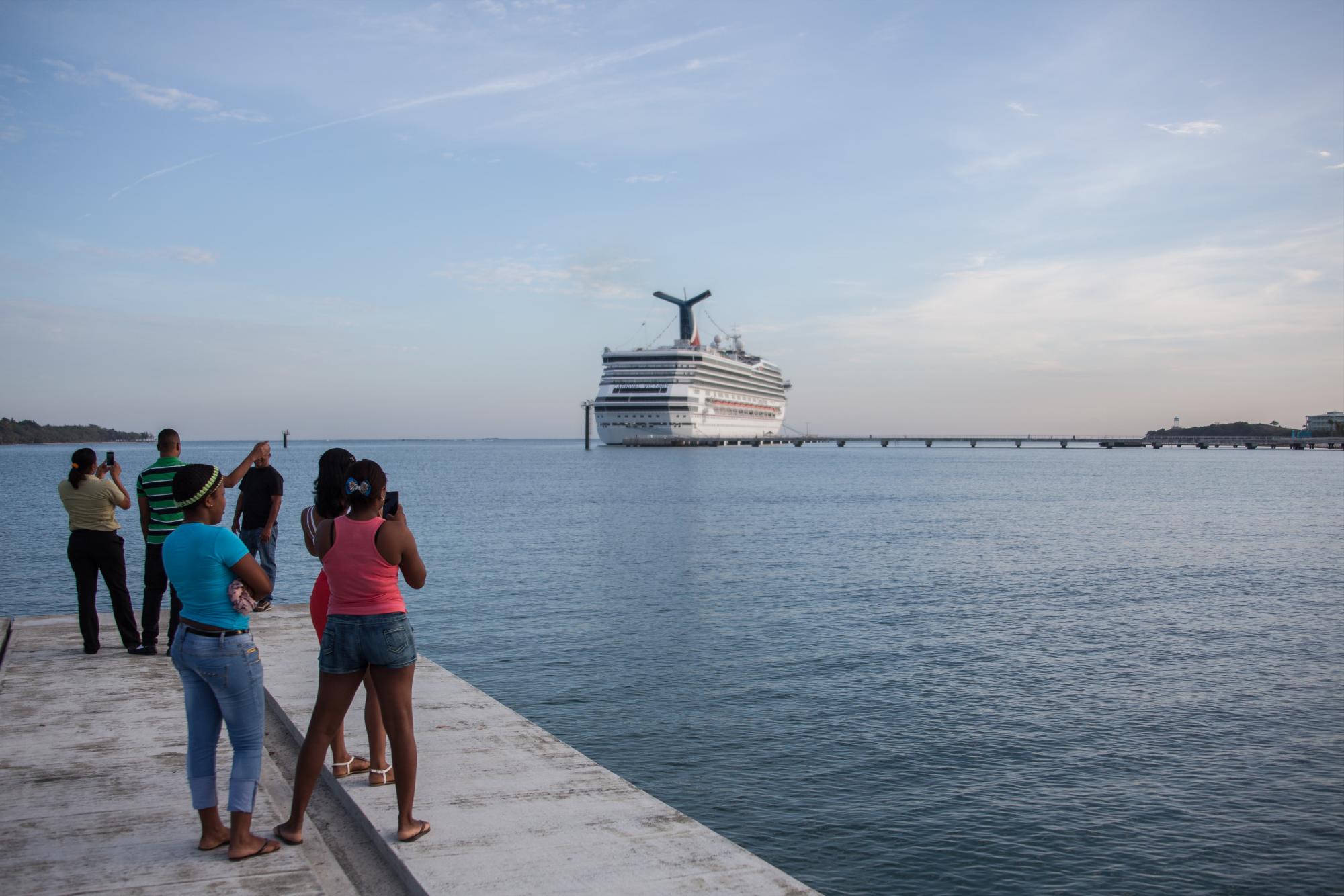 Varios jóvenes miran el Carnival Victory en el Club Náutico.