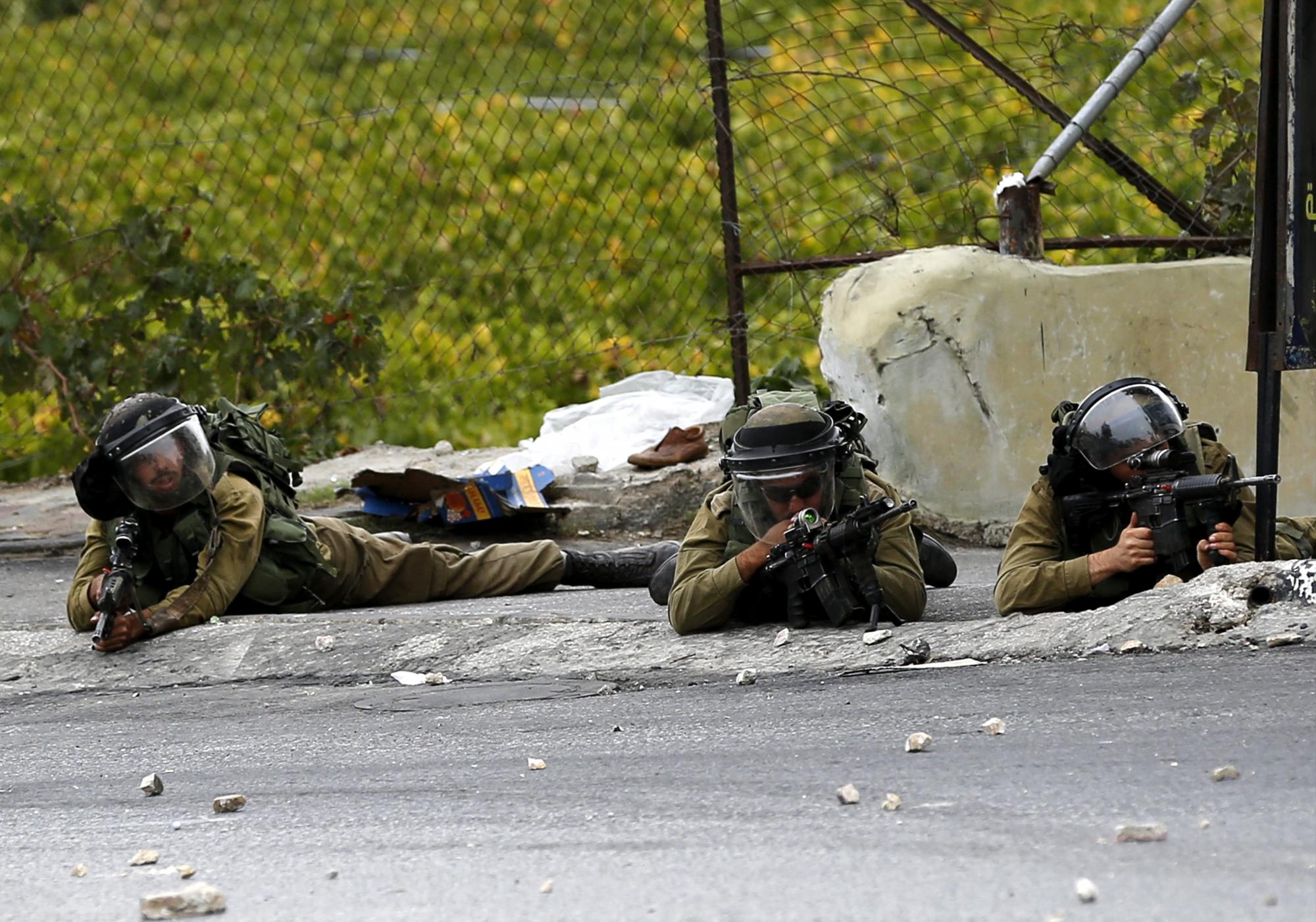 Soldados del ejército israelí toman posiciones durante un enfrentamiento con manifestantes palestinos en la ciudad cisjordana de Hebrón. 