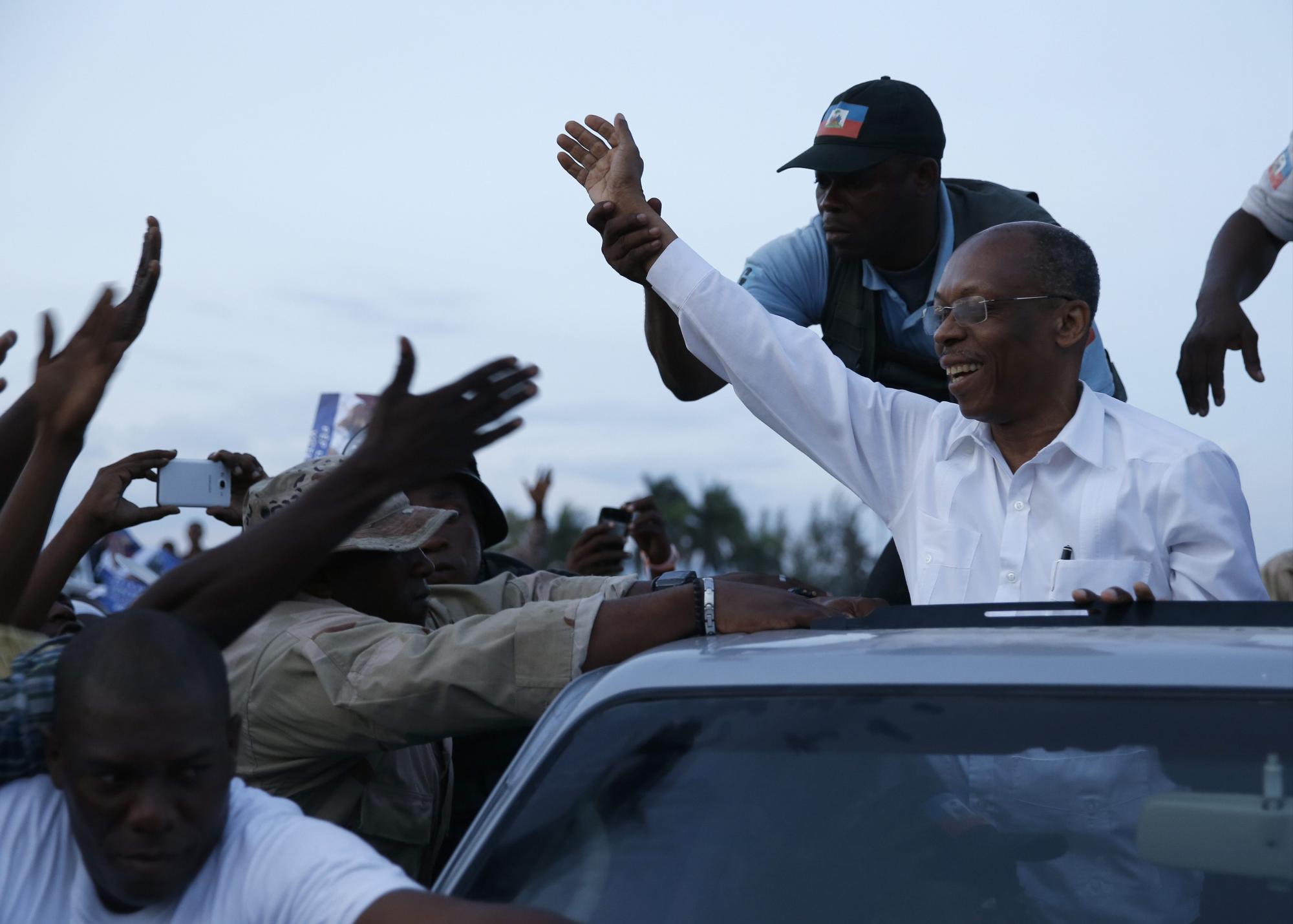 El expresidente Jean Bertrand Aristide saluda a simpatizantes durante un recorrido con la candidata a la Presidencia haitiana, Maryse Narcisse, del partido Familia Lavalas.Orlando Barría