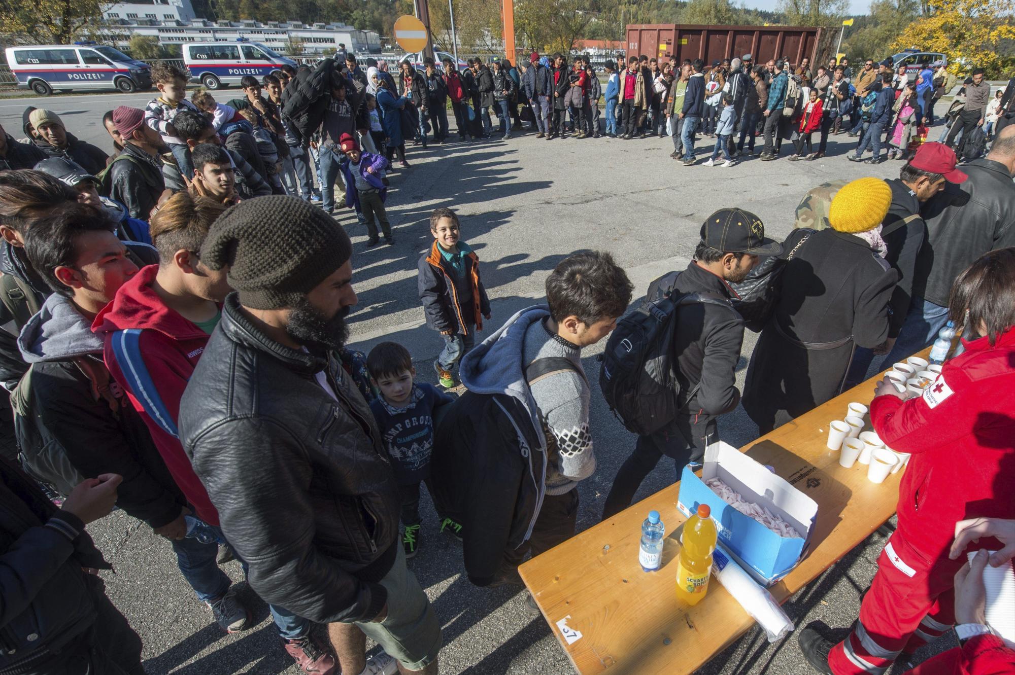 Voluntarios distribuyen comida y bebida a refugiados en la frontera entre Austria y Alemania en Passau, Alemania. 