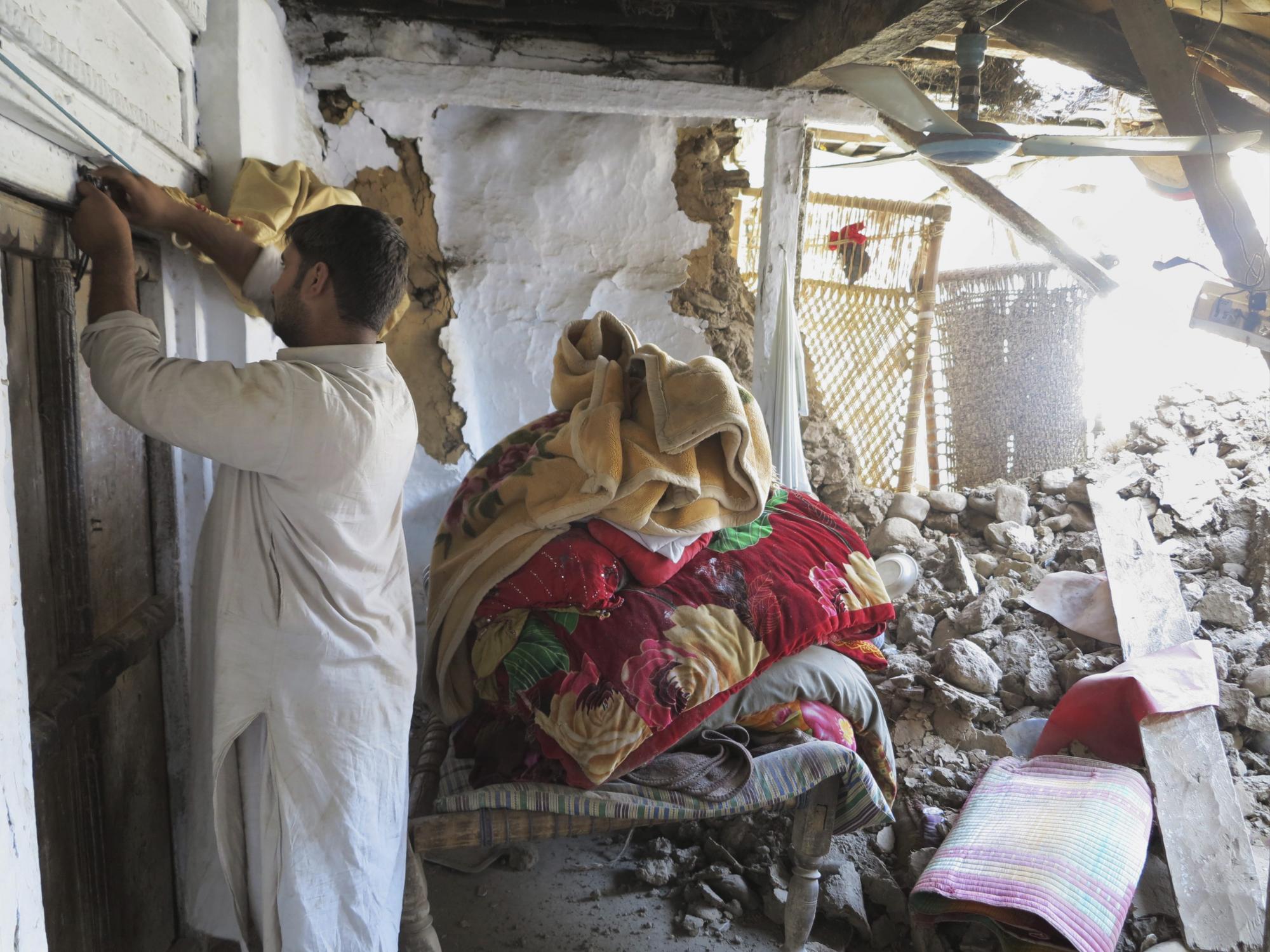Un hombre inspecciona una vivienda destrozada tras el terremoto de 7.7 grados de magnitud en el Valle del Swat en Pakistán hoy, 27 de octubre de 2015.  