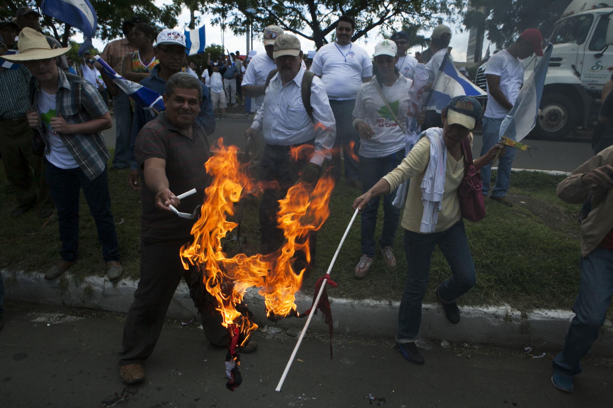 Manifestantes queman una bandera del Frente Sandinista de Liberación Nacional.