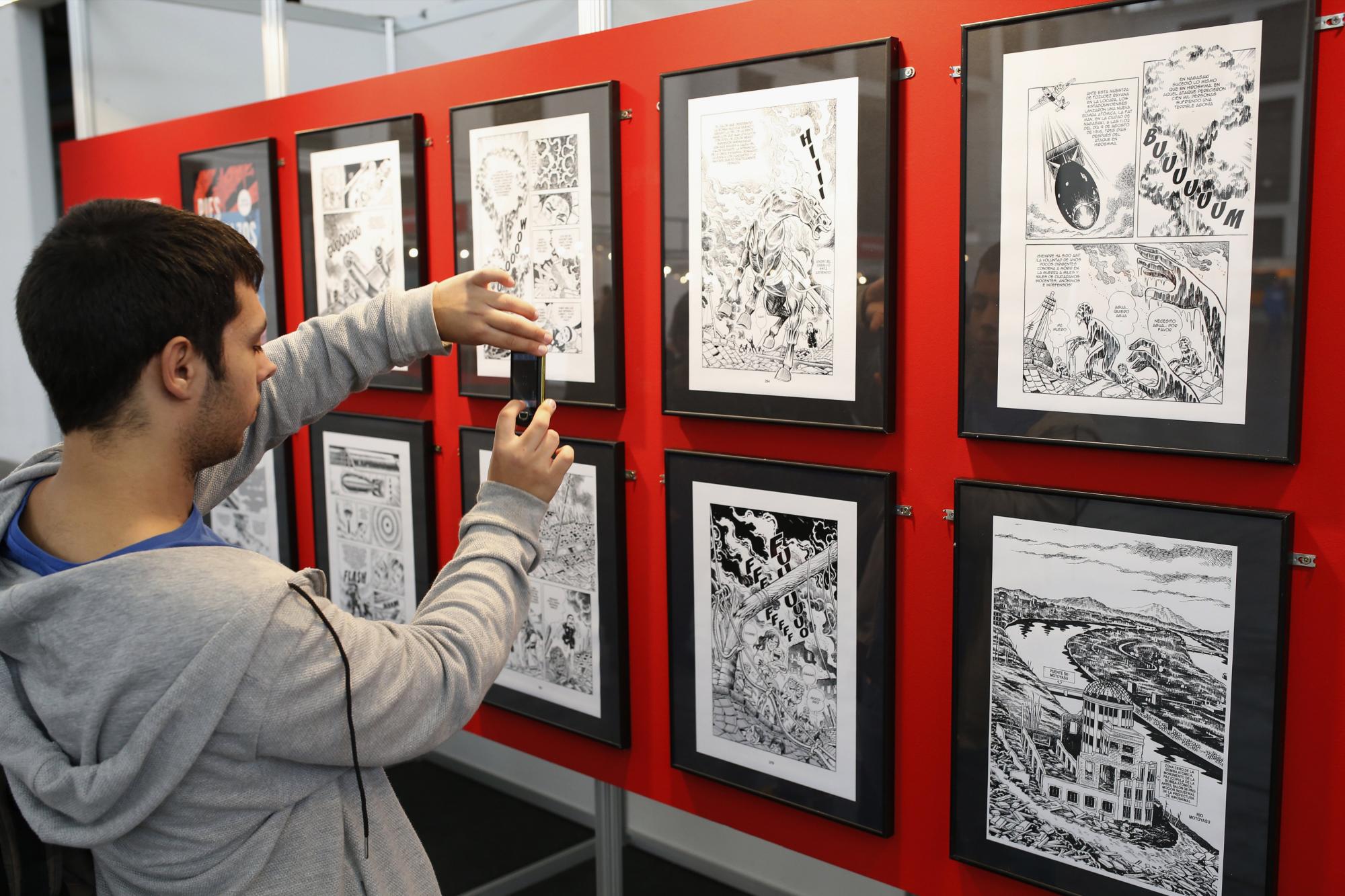 Un visitante fotografía la exposición “Mangas Nucleares”, que el Salón del Manga de Barcelona, inaugurado hoy, dedica a los bombardeos atómicos de Hiroshima y Nagasaki, tras abrir sus puertas con las entradas agotadas para el fin de semana. 