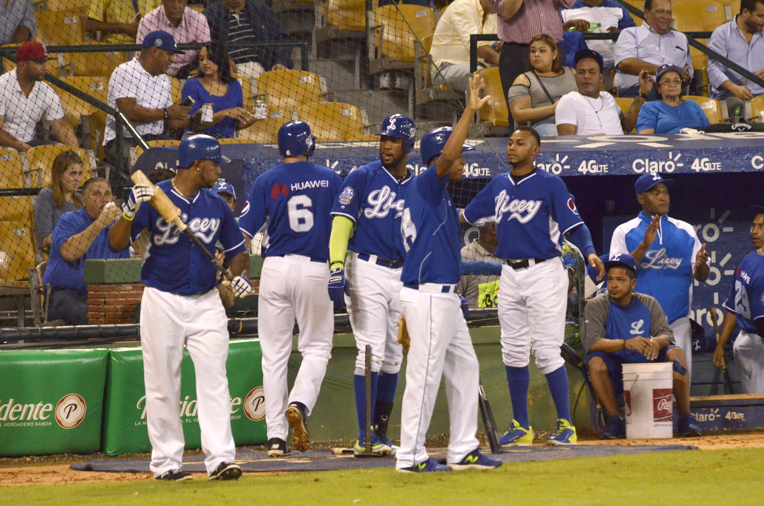 Jugadores azules celebran tras anotar una carrera.
