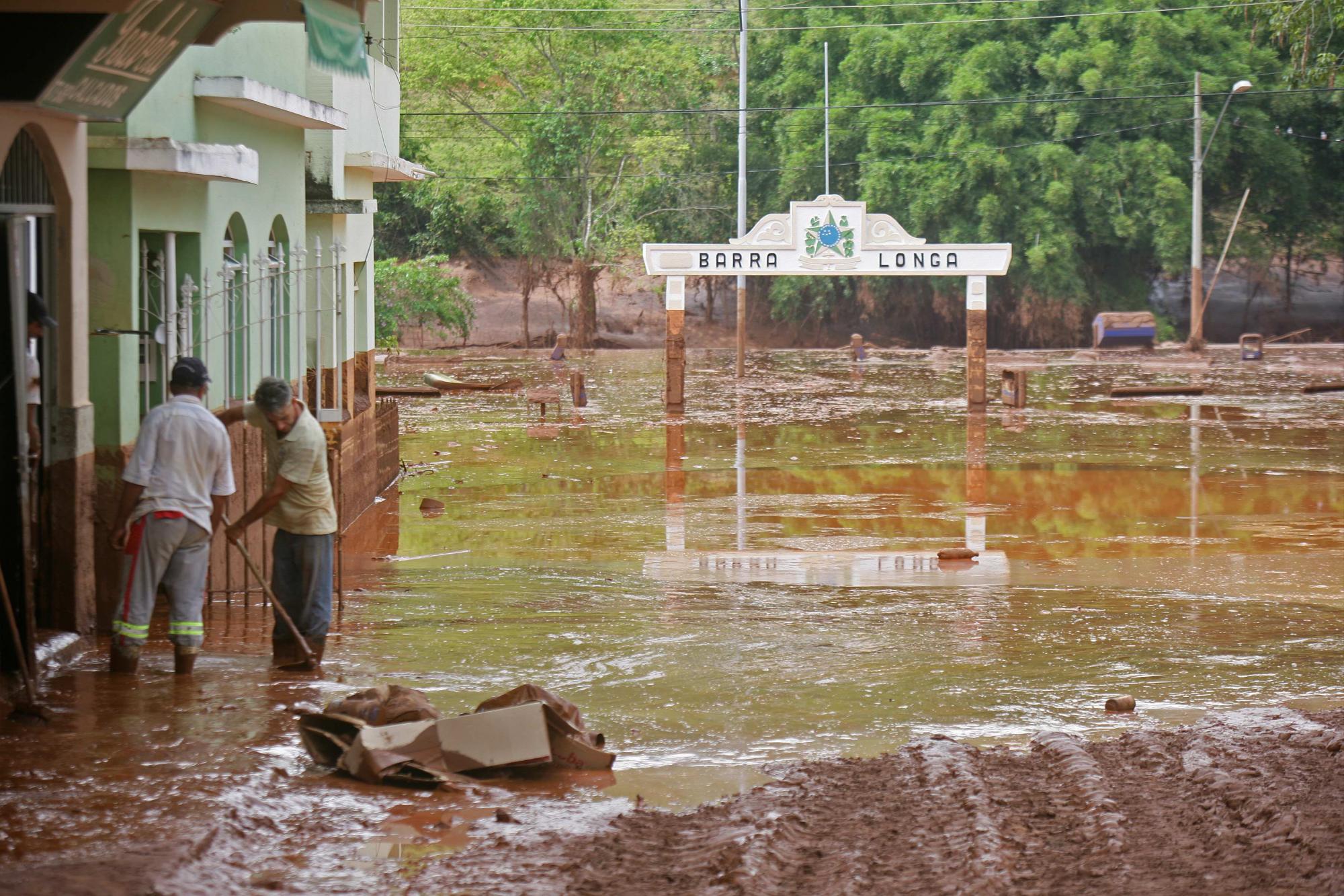 Personas sacan lodo de su casa tras la ruptura de los diques de contención de un depósito de residuos a 60 km de la ciudad de Mariana, en Barra Longa en el estado de Minas Gerais (Brasil). 