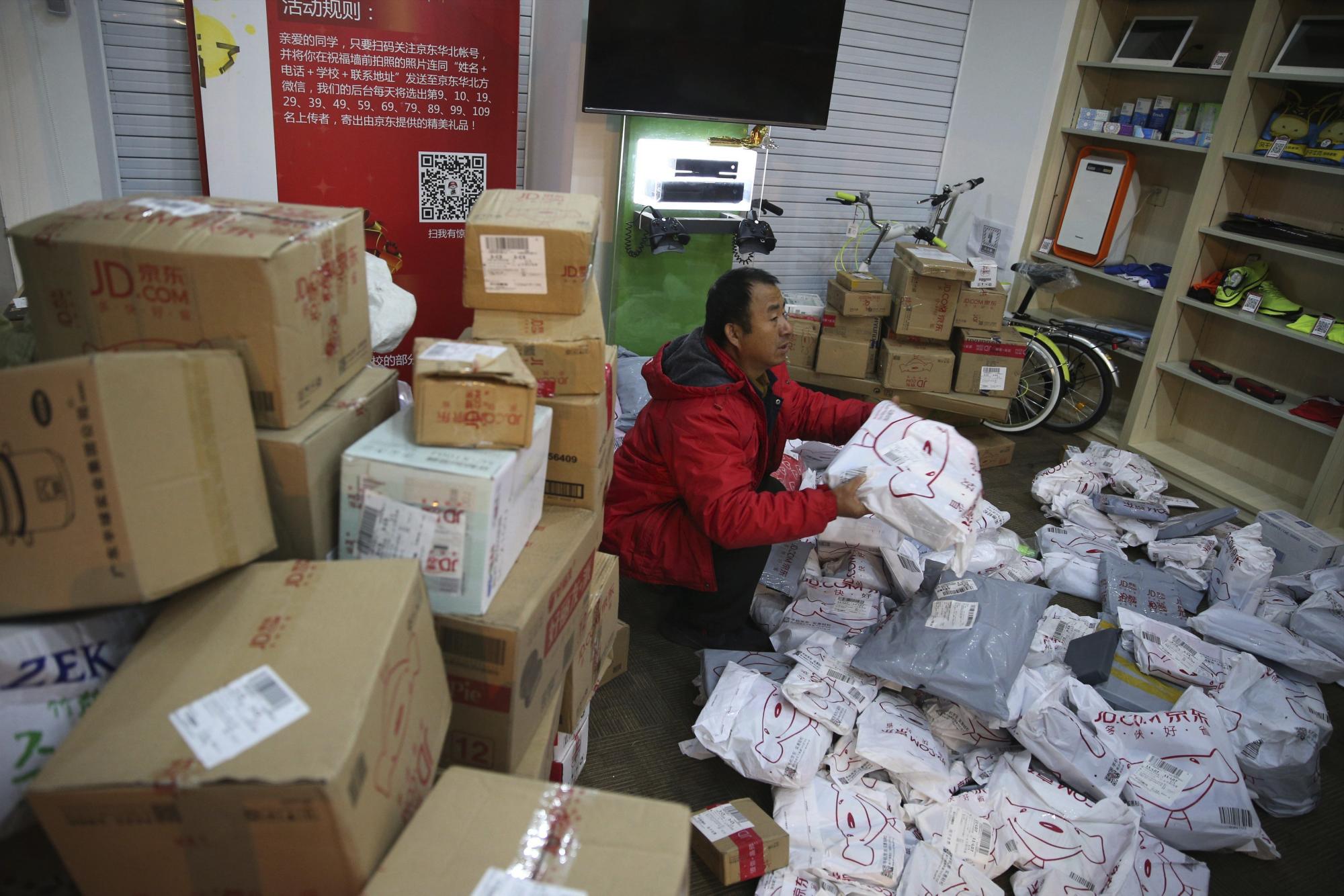 Empleados ordenan paquetes a las puertas de JD.com, una tienda electrónica, en una universidad en Pekín (China) hoy, 11 de noviembre de 2015. 