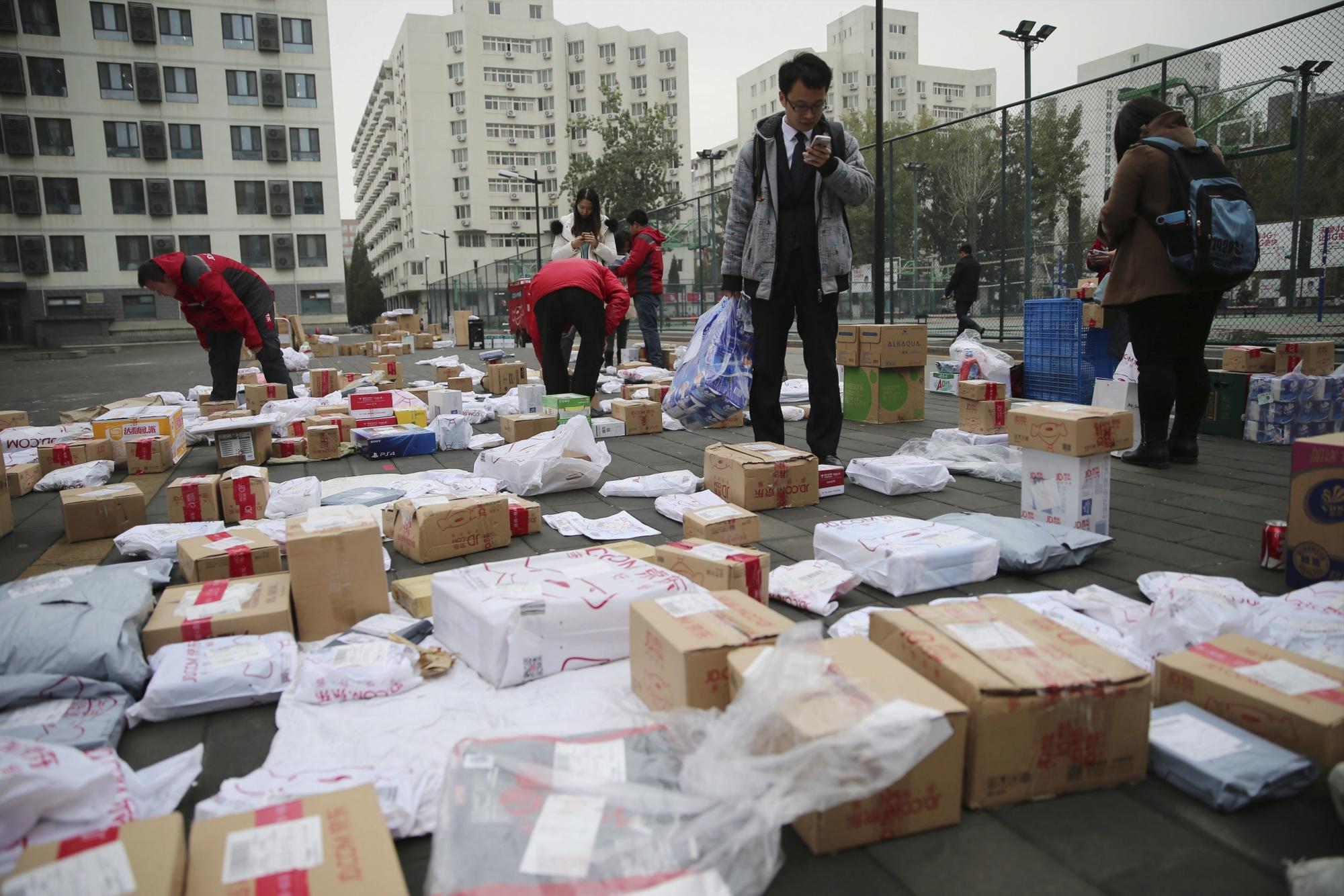 Consumidores buscan sus paquetes a las puertas de JD.com, una tienda electrónica, en una universidad en Pekín (China).