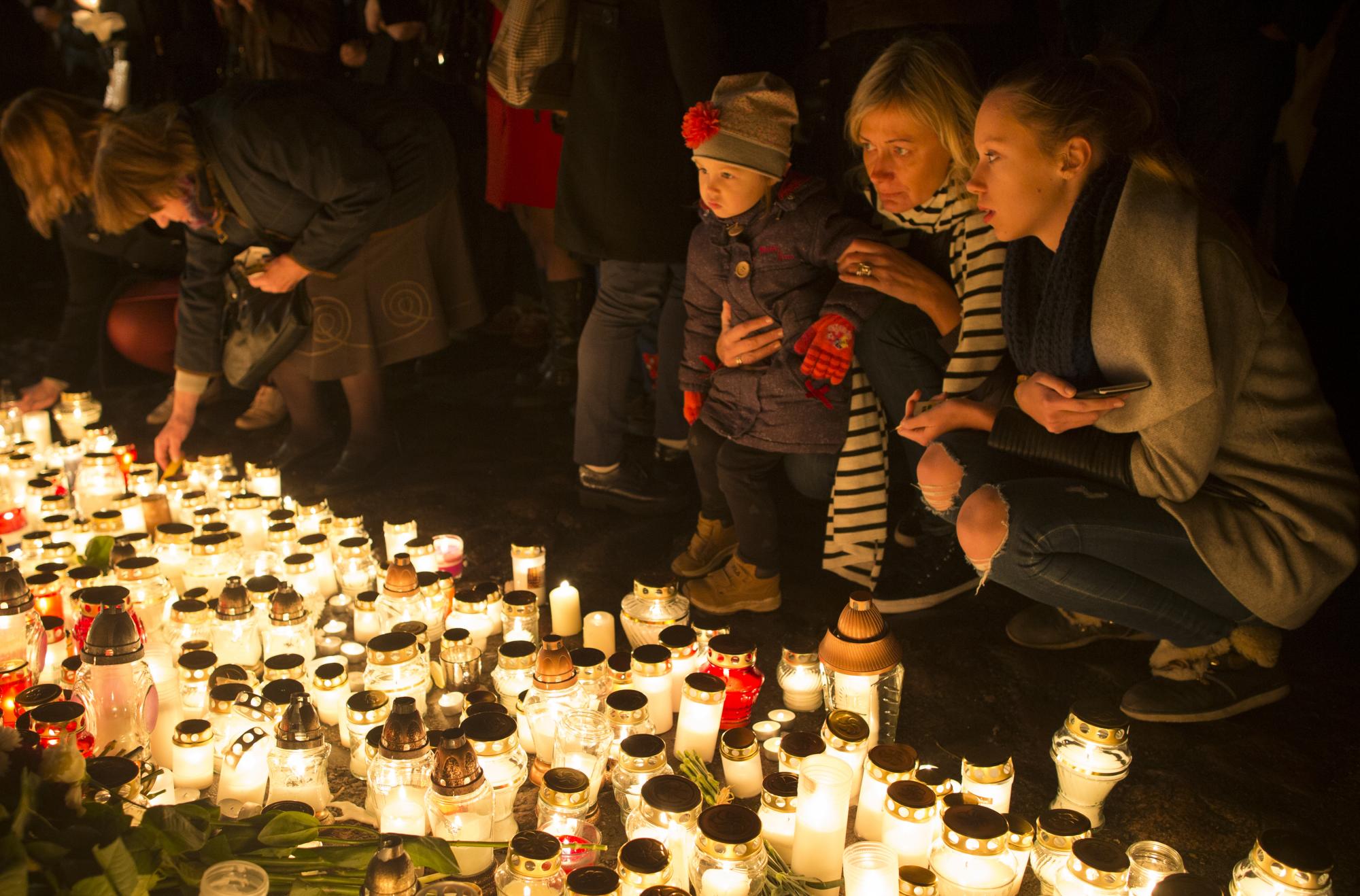 Las velas se colocan frente a la embajada de Francia en Vilnius, Lituania, Sábado, 14 de noviembre 2015, a las víctimas de los ataques del viernes en París. El presidente francés, Francois Hollande, dijo que más de 120 personas murieron la noche del viernes en tiroteos en los cafés de París, atentados suicidas cerca de estadio nacional de Francia y una toma de rehenes masacre dentro de una sala de conciertos.