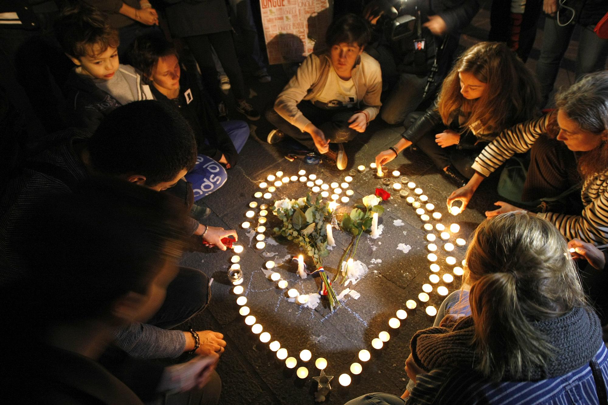 La gente enciende velas en forma de corazón, en el antiguo puerto de Marsella, sur de Francia, Sábado, 14 de noviembre 2015, después de los atentados de París el viernes. El presidente francés, Francois Hollande se comprometió a atacar al grupo Estado Islámico sin piedad como el grupo yihadista admitió su responsabilidad Sábado de orquestar los ataques más mortales infligidas a Francia desde la Segunda Guerra Mundial