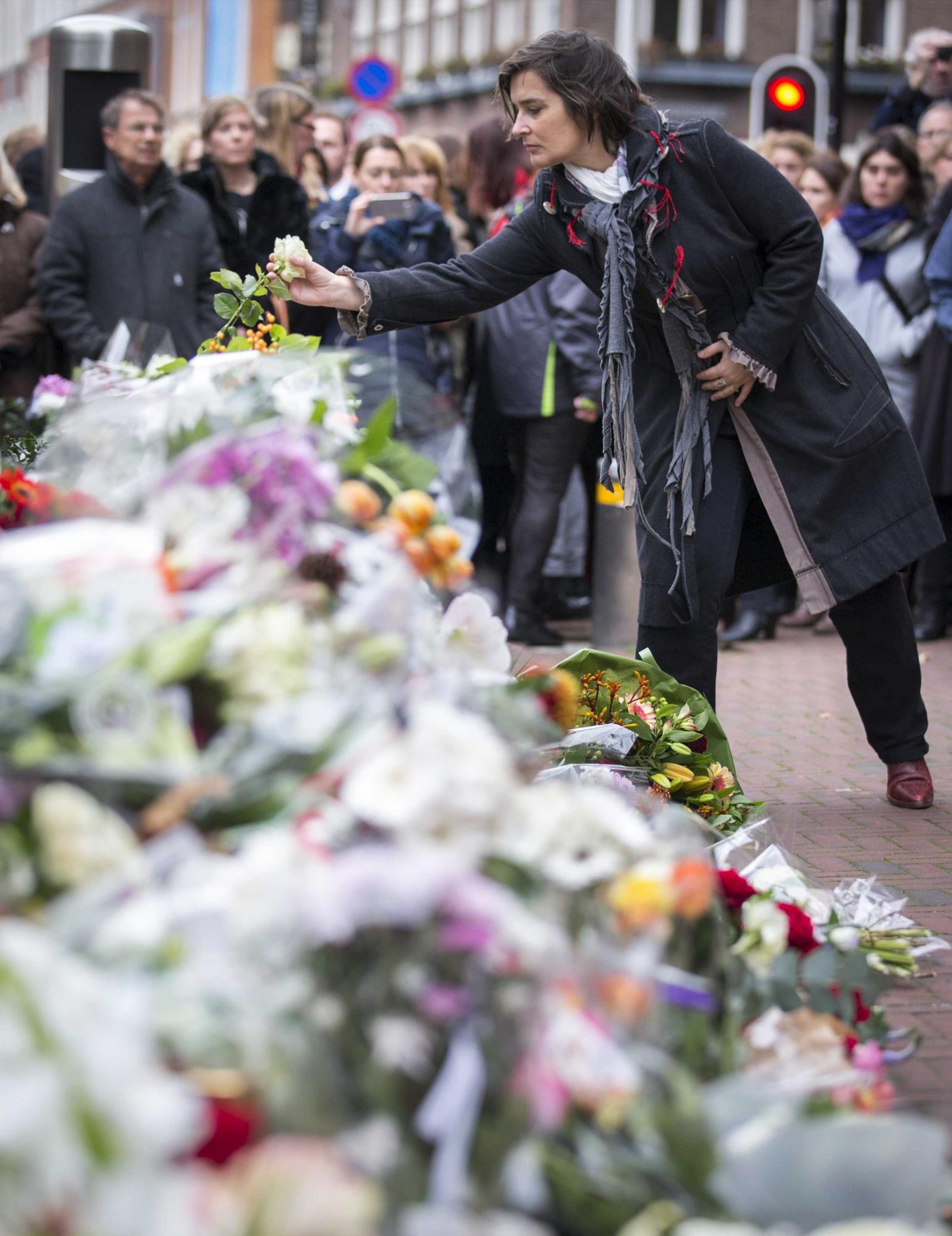 Varias personas depositan flores y muestran sus condolencias en el homenaje a las víctimas de los ataques terroristas de París organizado frente a la embajada francesa en La Haya (Holanda) hoy, 16 de noviembre de 2015. Al menos 129 personas fueron asesinadas el pasado 13 de Noviembre en una serie de ataques terroristas en la ciudad de París. 