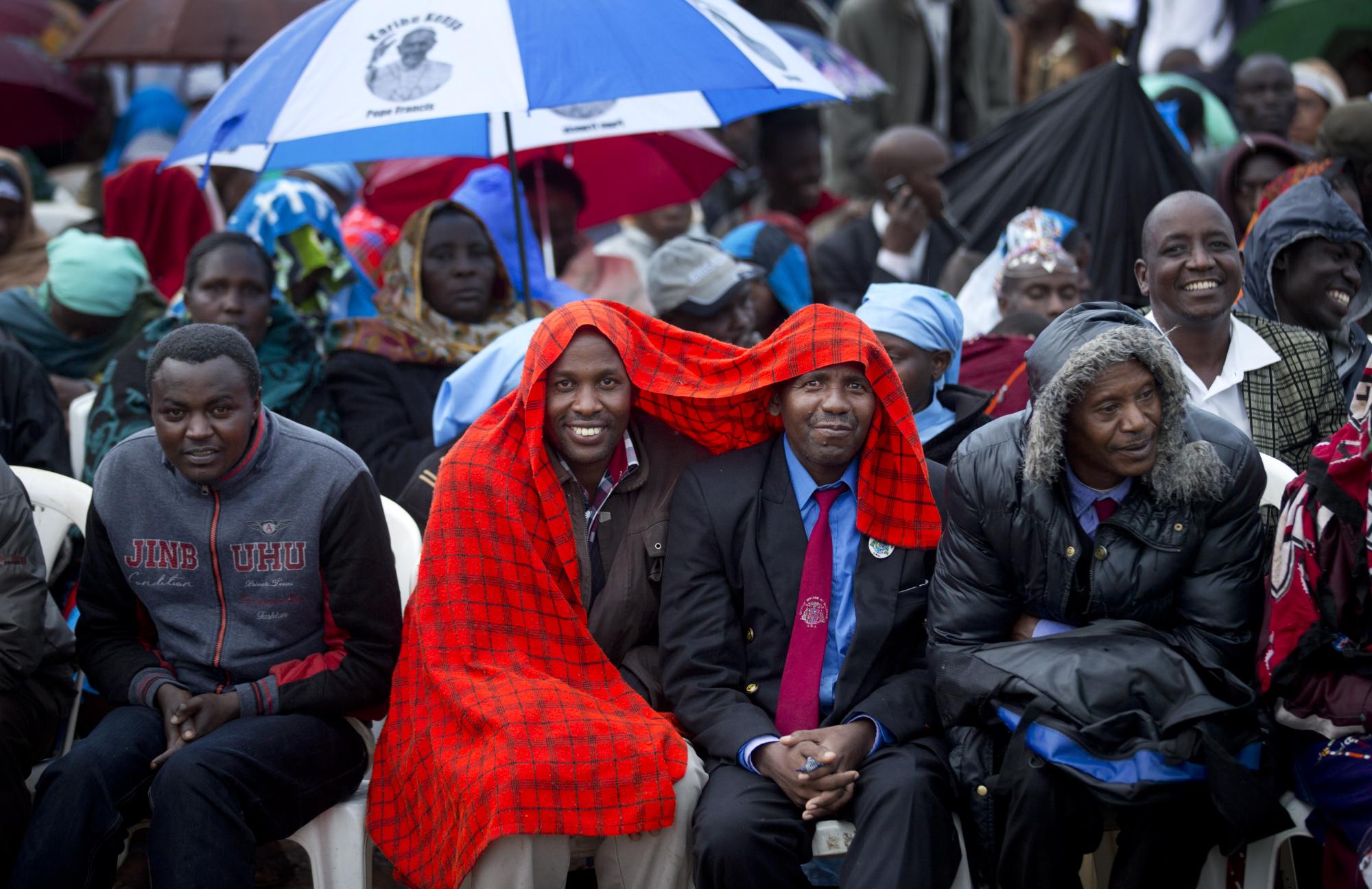 Kenianos católicos aguardan justo después del amanecer bajo la lluvia y en el lodo con el fin de asistir a una misa presidida por el papa Francisco en el campus de la Universidad de Nairobi en Kenia, el jueves 26 de noviembre de 2015.