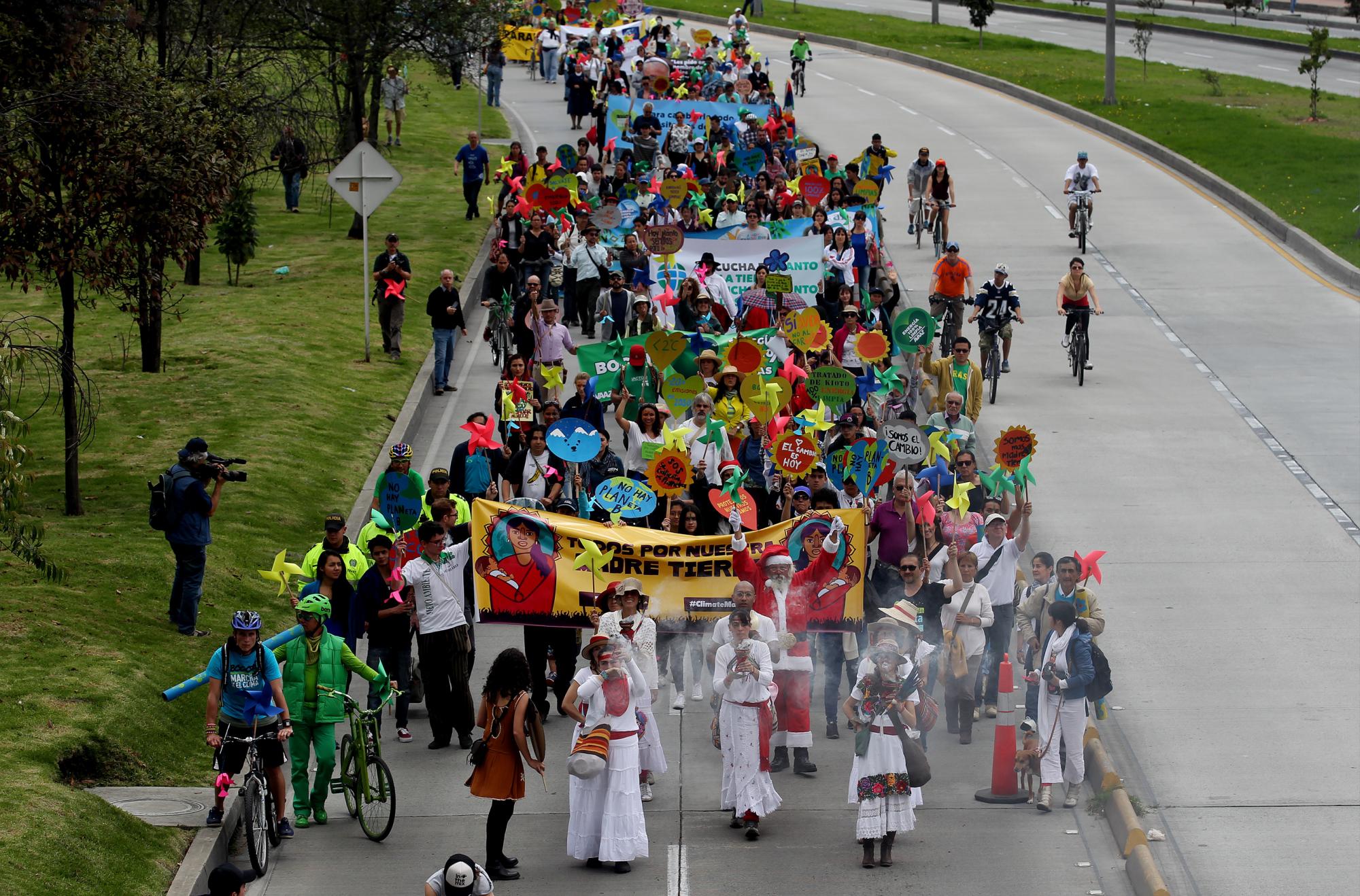Decenas de personas marchan para pedir, a los líderes mundiales reunidos en París en la Cumbre del Clima COP21, que tomen medidas contra el calentamiento global hoy, domingo 29 de noviembre de 2015, en Bogotá (Colombia).