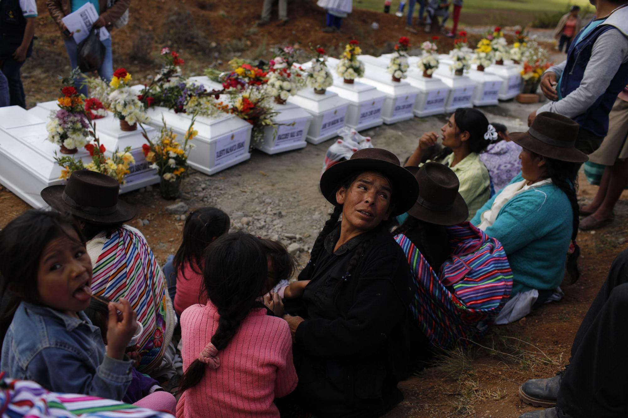 En esta imagen, tomada el 26 de noviembre de 2015, familiares se reúnen junto a los ataúdes que contienen los restos exhumados de una fosa común de 34 personas asesinadas por Sendero Luminoso en 1992 durante un entierro comunitario en el cementerio de Valle Esmeralda de Huayao, en Perú. Según los sobrevivientes, la noche del 10 de octubre de 1992, más de 100 senderistas rodearon la aldea y mataron a ancianos, hombres, mujeres y niños en venganza porque los agricultores habían formado un comité de autodefensa y rechazado a los maoístas.