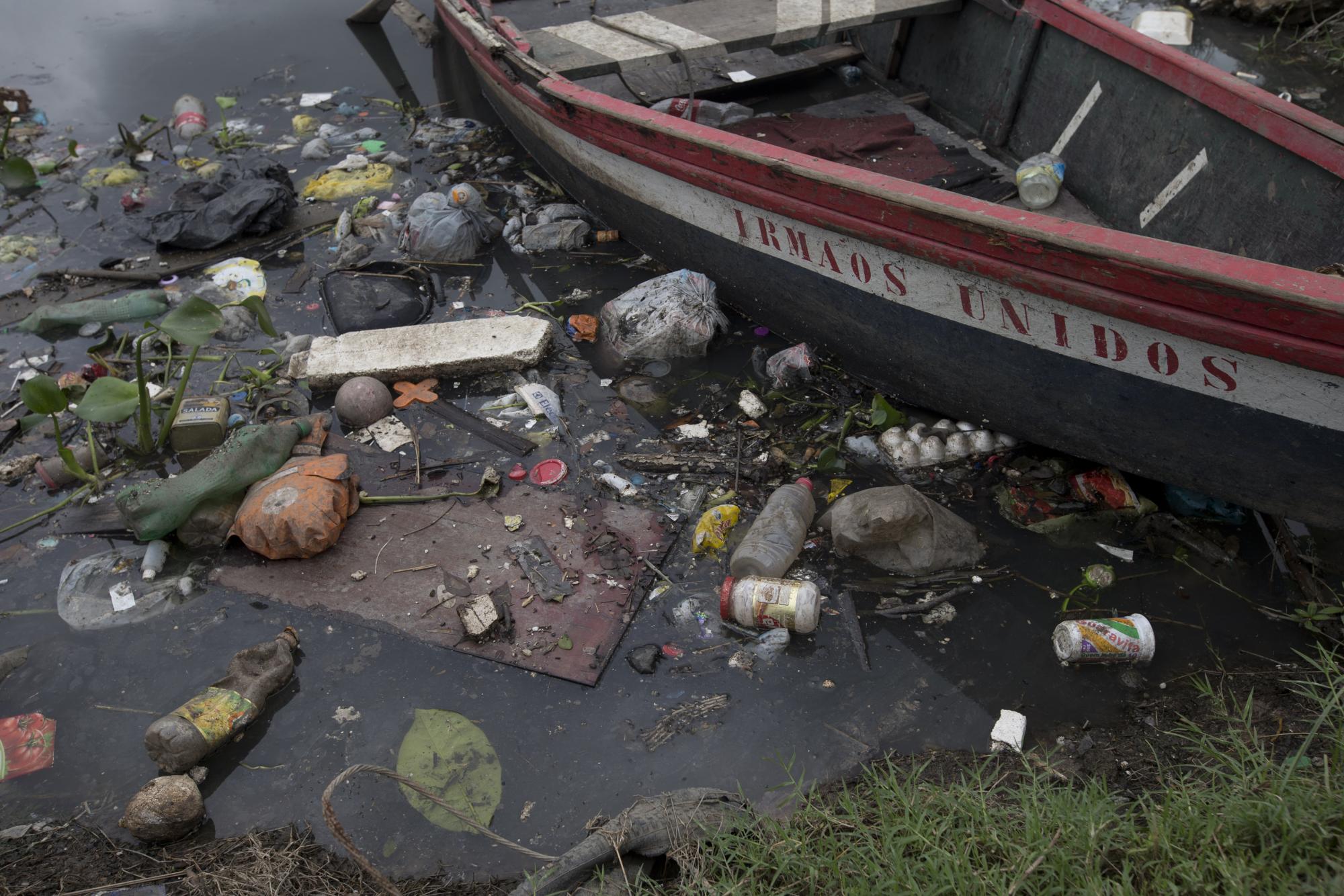 En esta imagen, tomada el 5 de noviembre de 2015, basuras rodean un bote atracado en las orillas del río Meriti, que desemboca en la bahía de Guanabara en Río de Janeiro, Brasil. Los canales de agua de Río, como ocurre en muchos países en desarrollo, están extremadamente contaminados porque la mayoría de las aguas residuales de la ciudad no se tratan ni recogen de forma adecuada. Gran parte de ellas llegan a la bahía de Guanabara. 