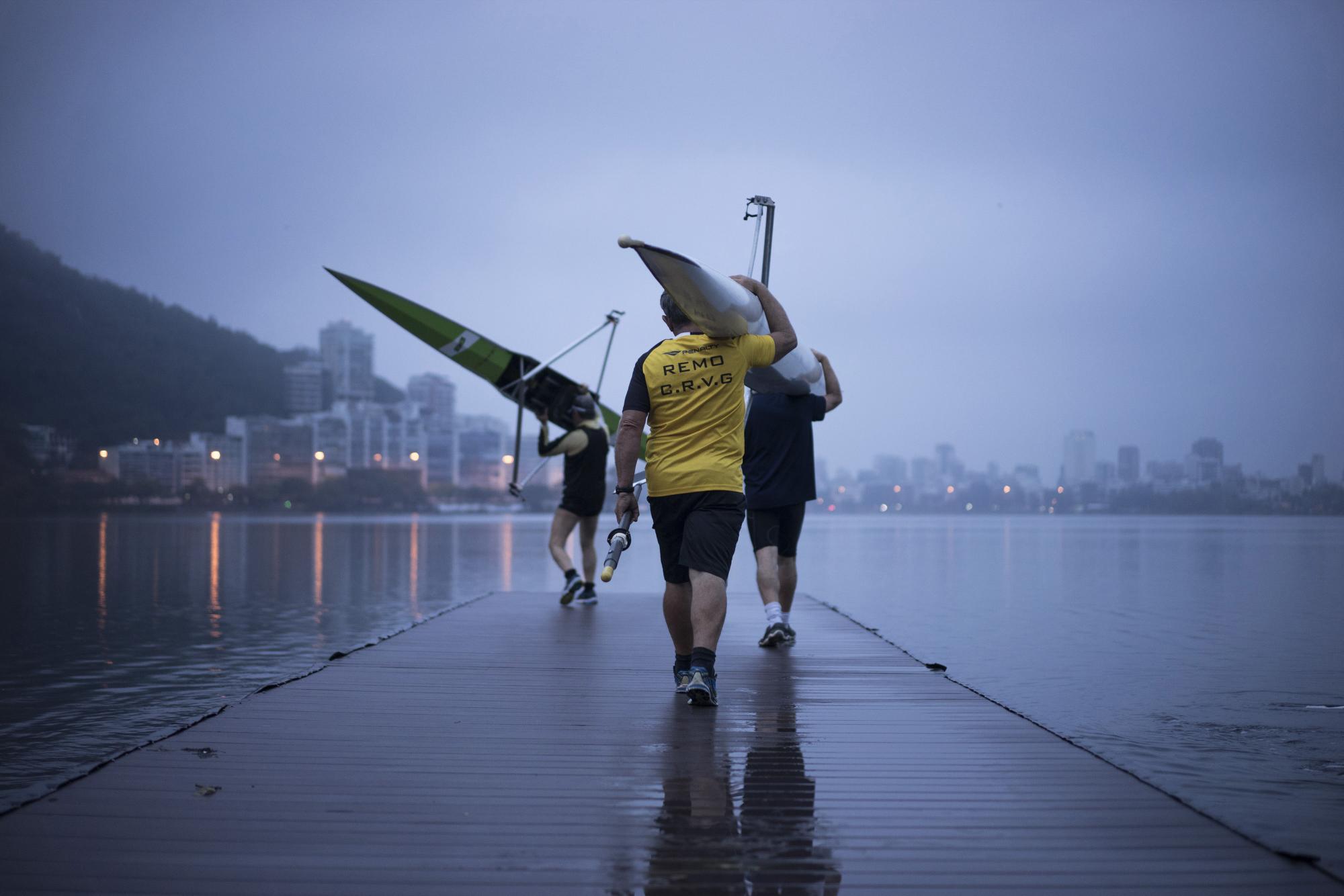 En esta imagen, tomada el 4 de noviembre de 2015, remeros cargan con sus botes en la laguna Rodrigo de Freitas en Río de Janeiro, Brasil. Los deportistas que participaron en las pruebas preolímpicas ensayaron con muchos trucos y tratamientos previos para evitar enfermedades, como poner lavandina en los remos, bañarse apenas salen del agua y tomar antibióticos. Pero nada de eso tiene efectos en los virus.