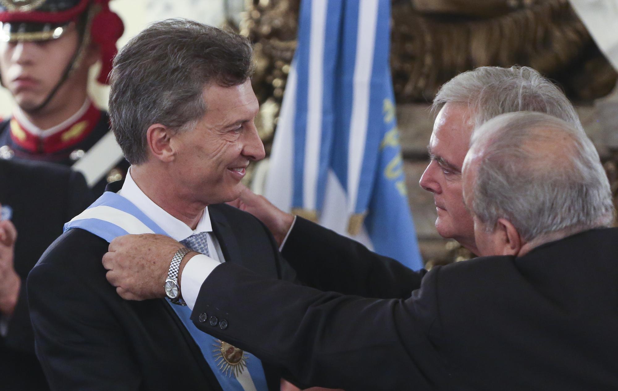 El nuevo presidente argentino, Mauricio Macri (i), recibe la banda presidencial de manos del presidente del Senado, Federico Pineda (d), en el acto de posesión, en el Salón Blanco de la Casa Rosada. 