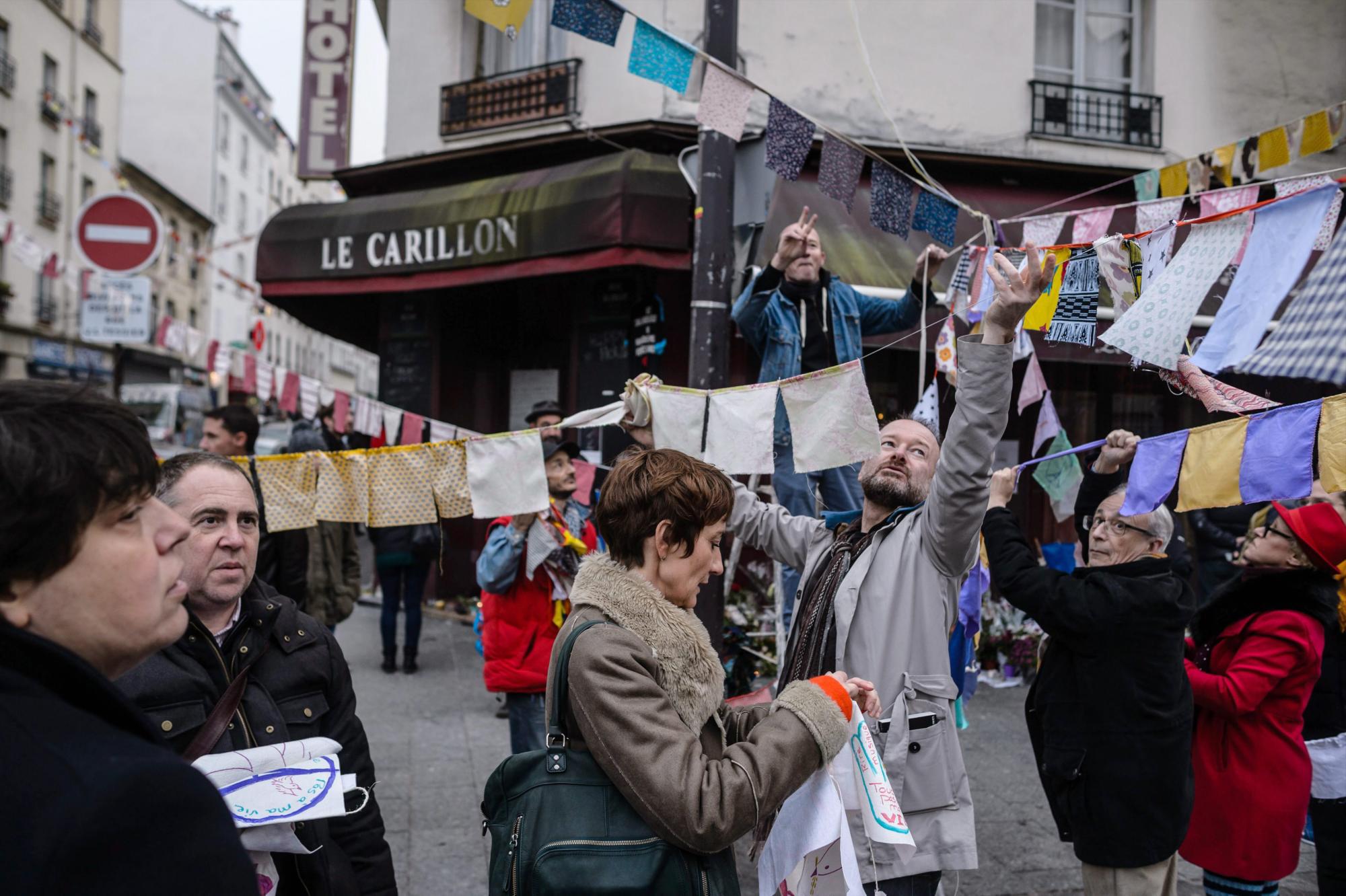 Los residentes locales de Carillon cafetería y restaurante Petit Cambodge adornan la calle con banderas de colores.