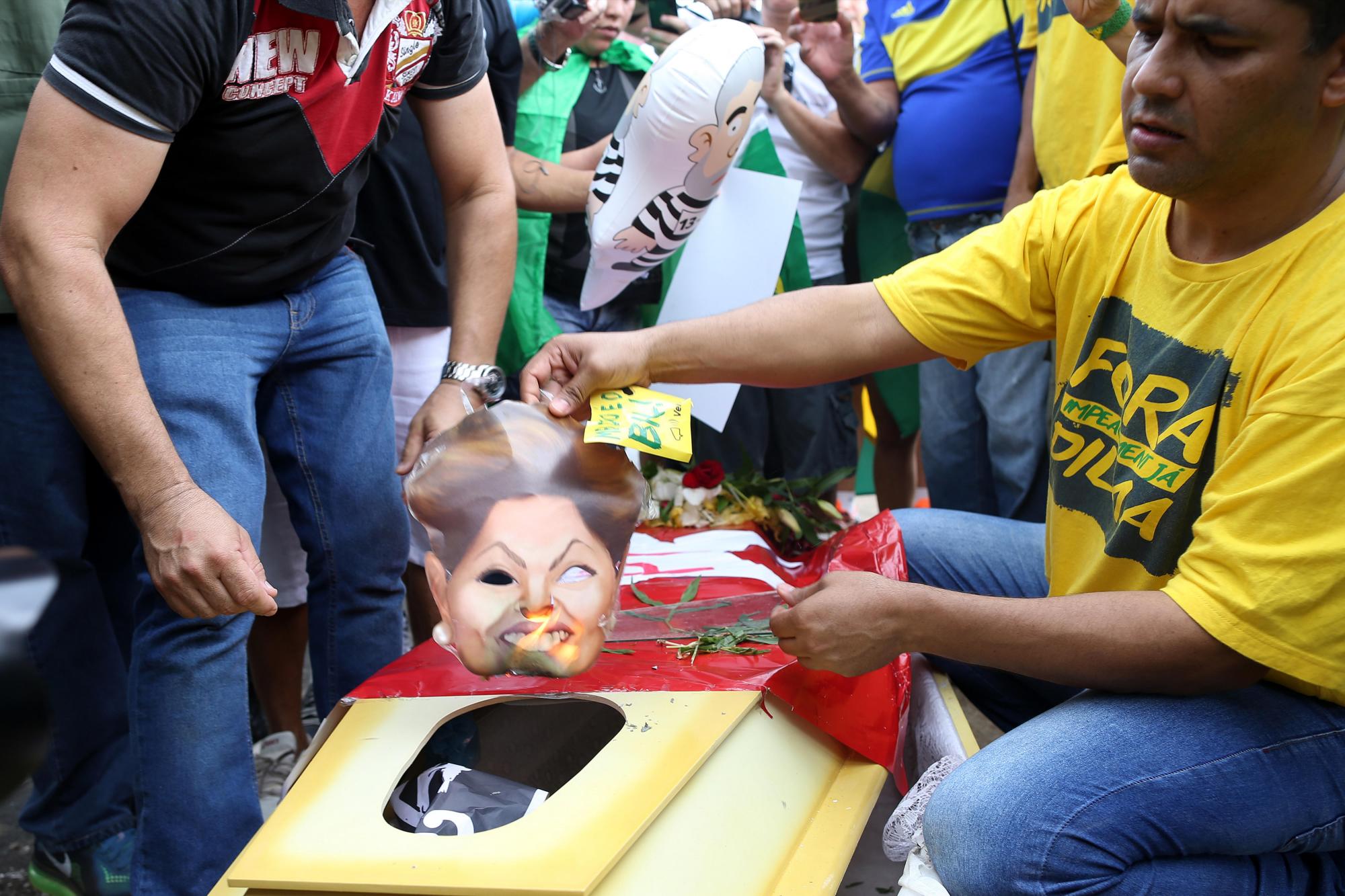 Manifestantes queman un ataúd con imágenes de la presidenta brasileña, Dilma Rousseff, hoy, domingo 13 de diciembre de 2015, en Brasilia (Brasil).