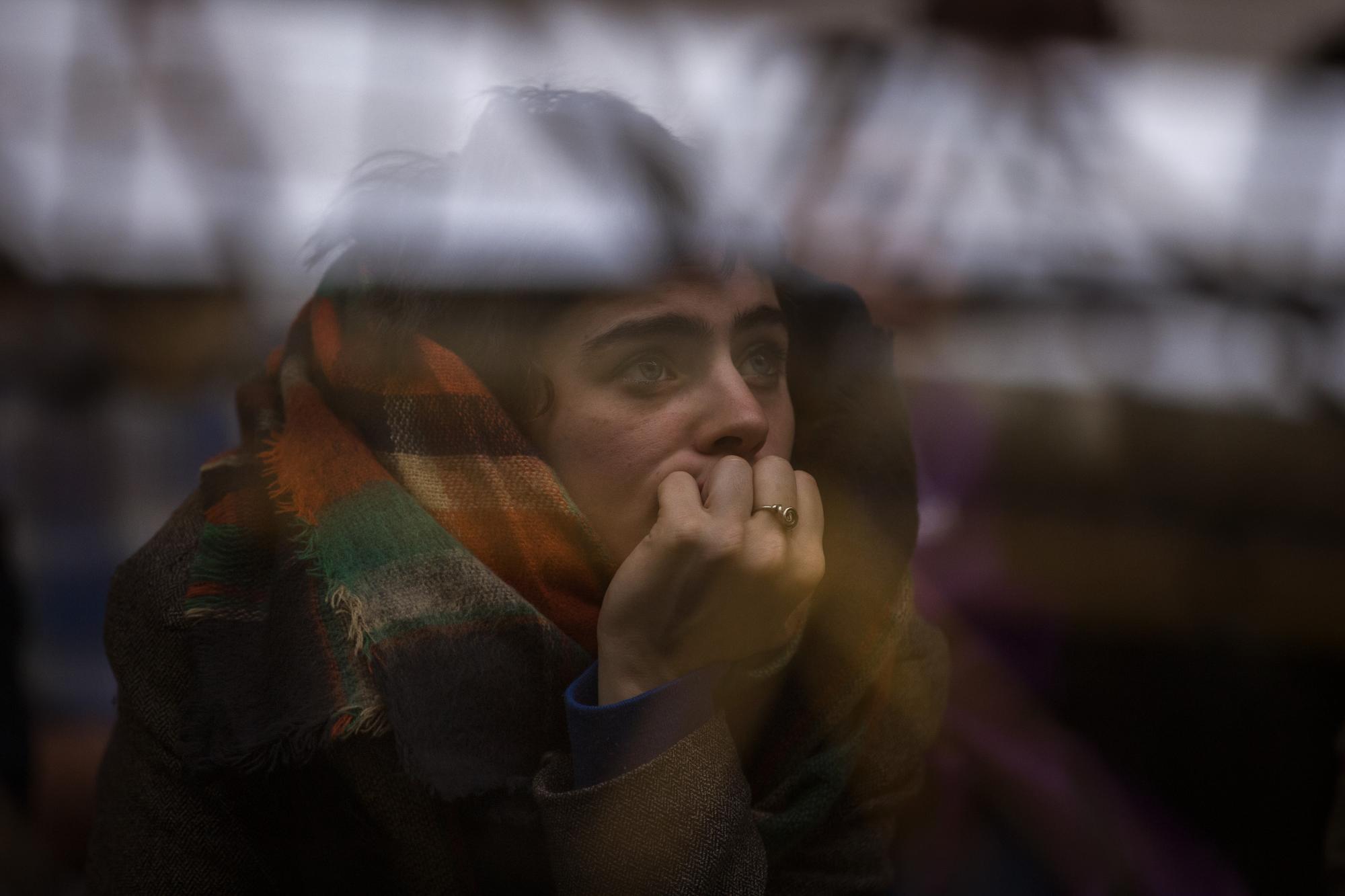 En esta imagen, tomada el 12 de diciembre de 2015, una mujer escucha al líder del partido Podemos, Pablo Iglesias, durante un acto electoral antes de las elecciones de 20 de diciembre, en Badalona, cerca de Barcelona, España. Las encuestas muestran que el Partido Popular del presidente Mariano Rajoy será el más votado, aunque no obtendría los apoyos necesarios para conservar la abrumadora mayoría que tiene en el Parlamento _ lo que supondría que tendría que asociarse con otra formación, probablemente Ciudadanos. Otra posibilidad podría ser una coalición entre los socialistas y Podemos. 