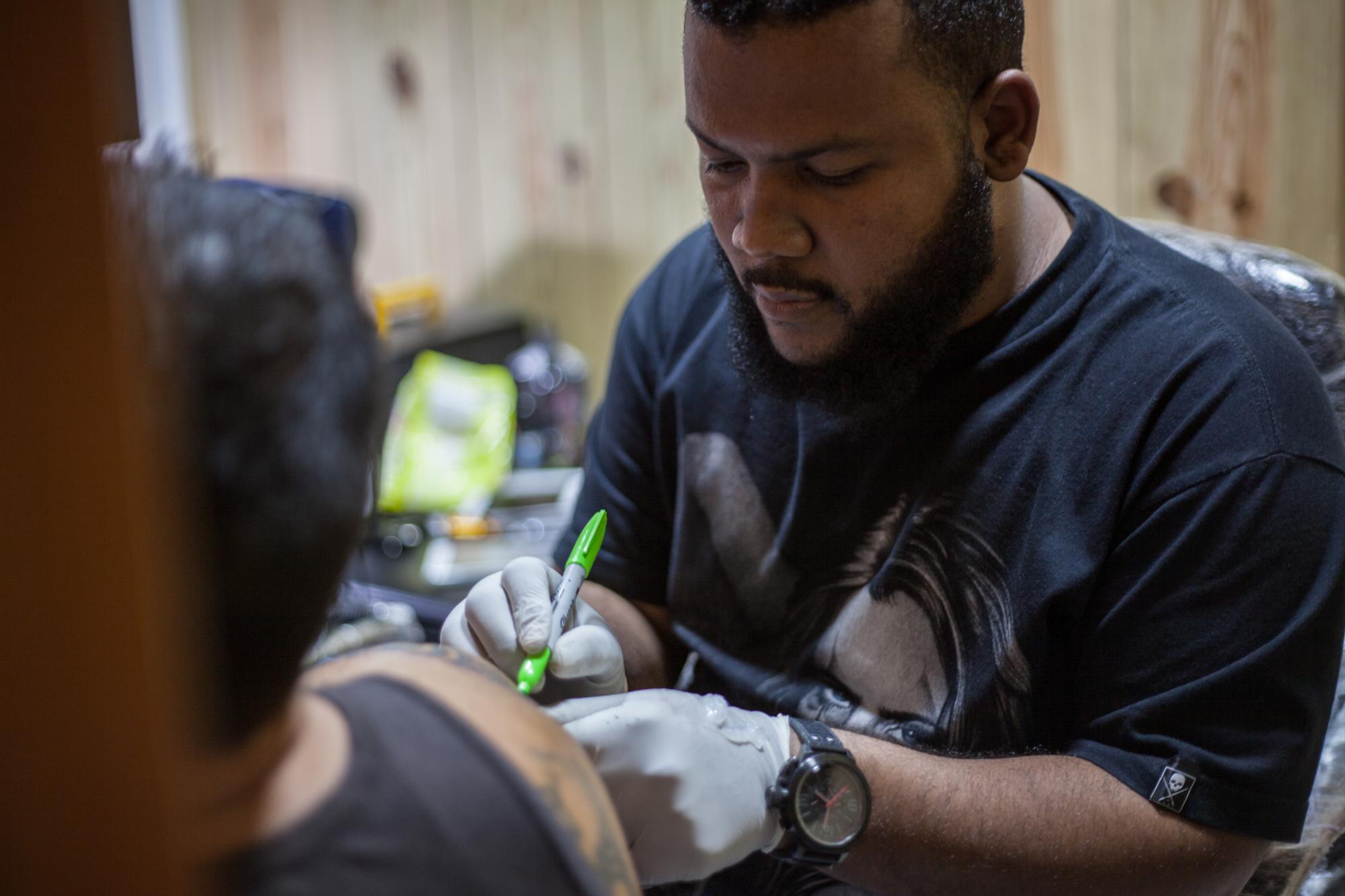 Michel Pantaléon trabajando con un cliente en Canoa Tatoo.