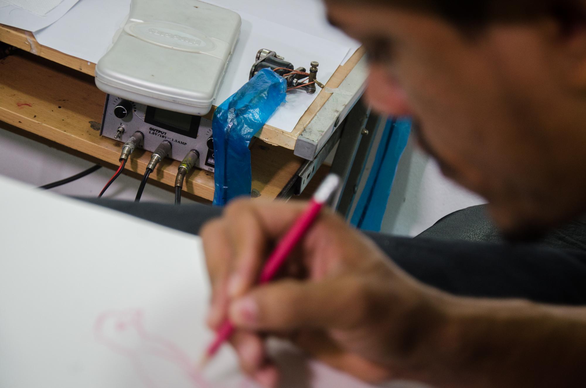 Edward Reyes de Dominican Tatoo dibujando un boceto.