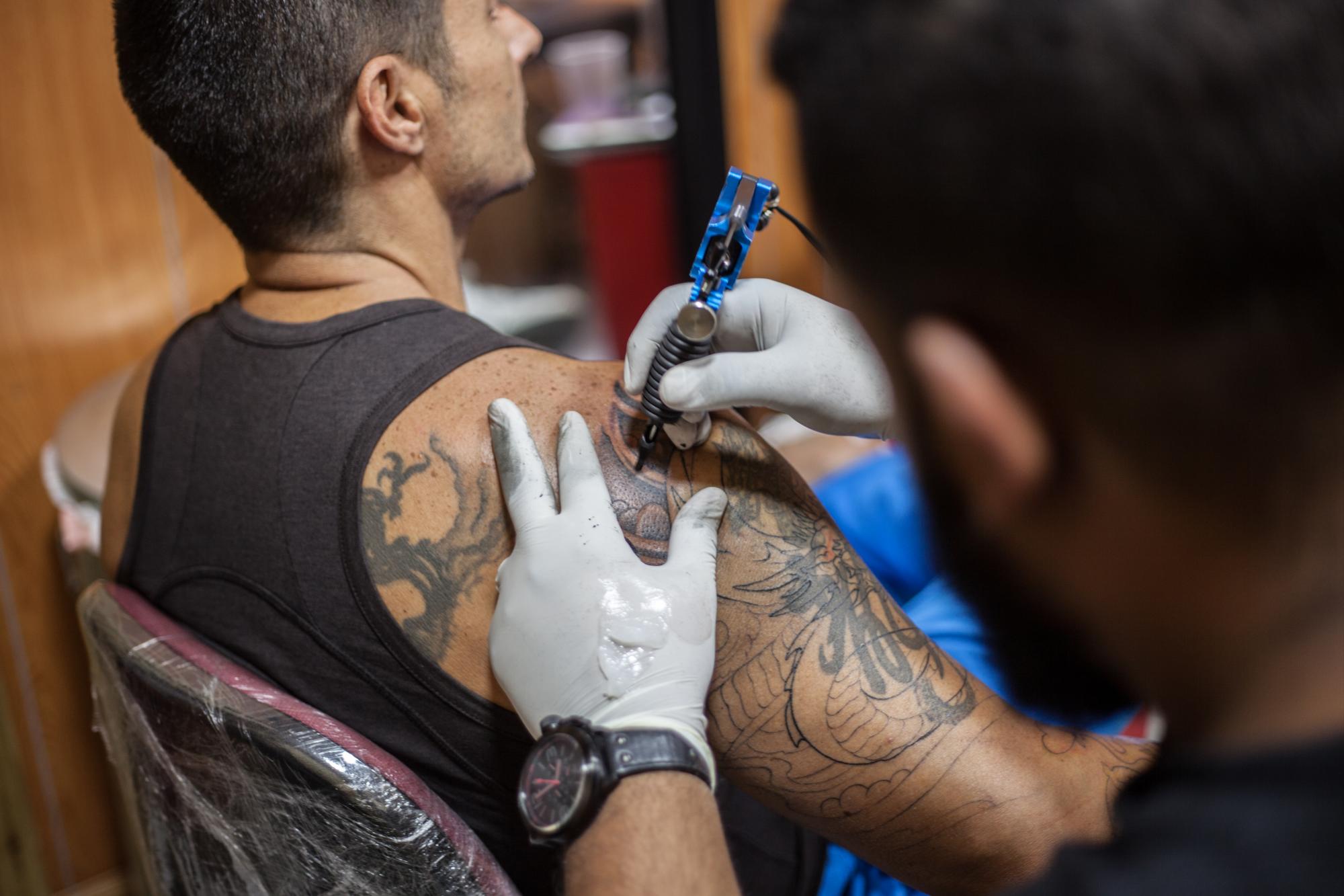 Michel Pantaléon trabajando con un cliente en Canoa Tatoo.