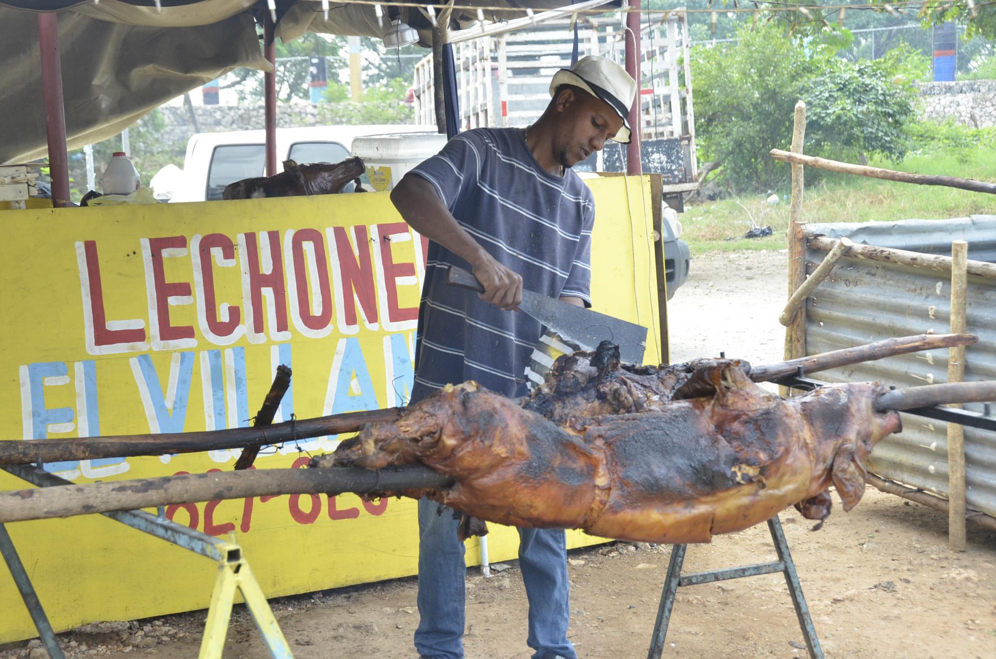 Carlos Reynoso corta una pieza de un cerdo asado en la lechonera El Villano.
