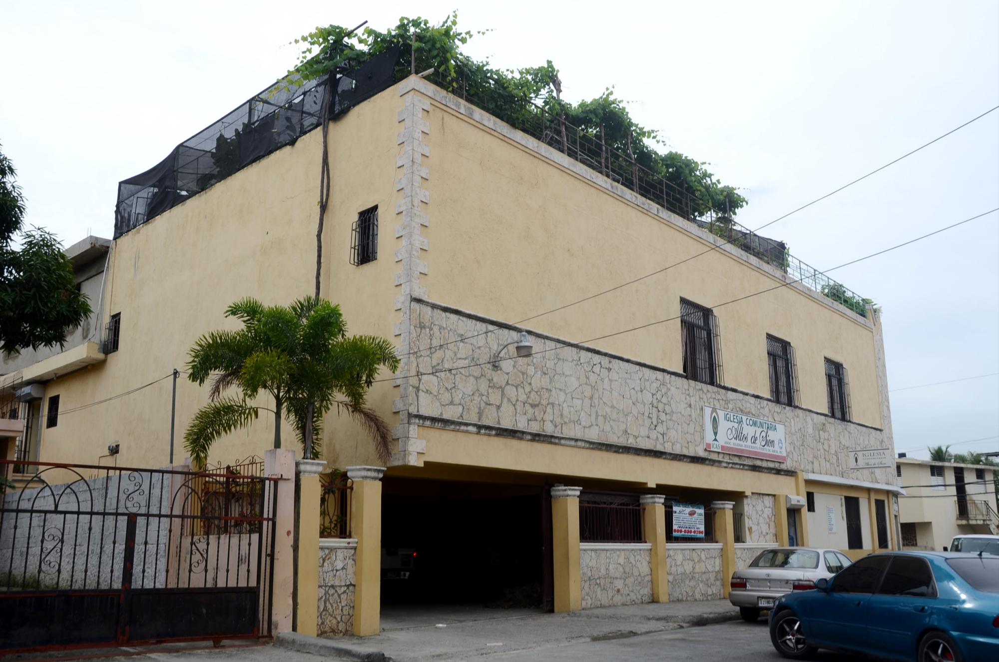 El verdor del huerto sobresale del techo del edificio.