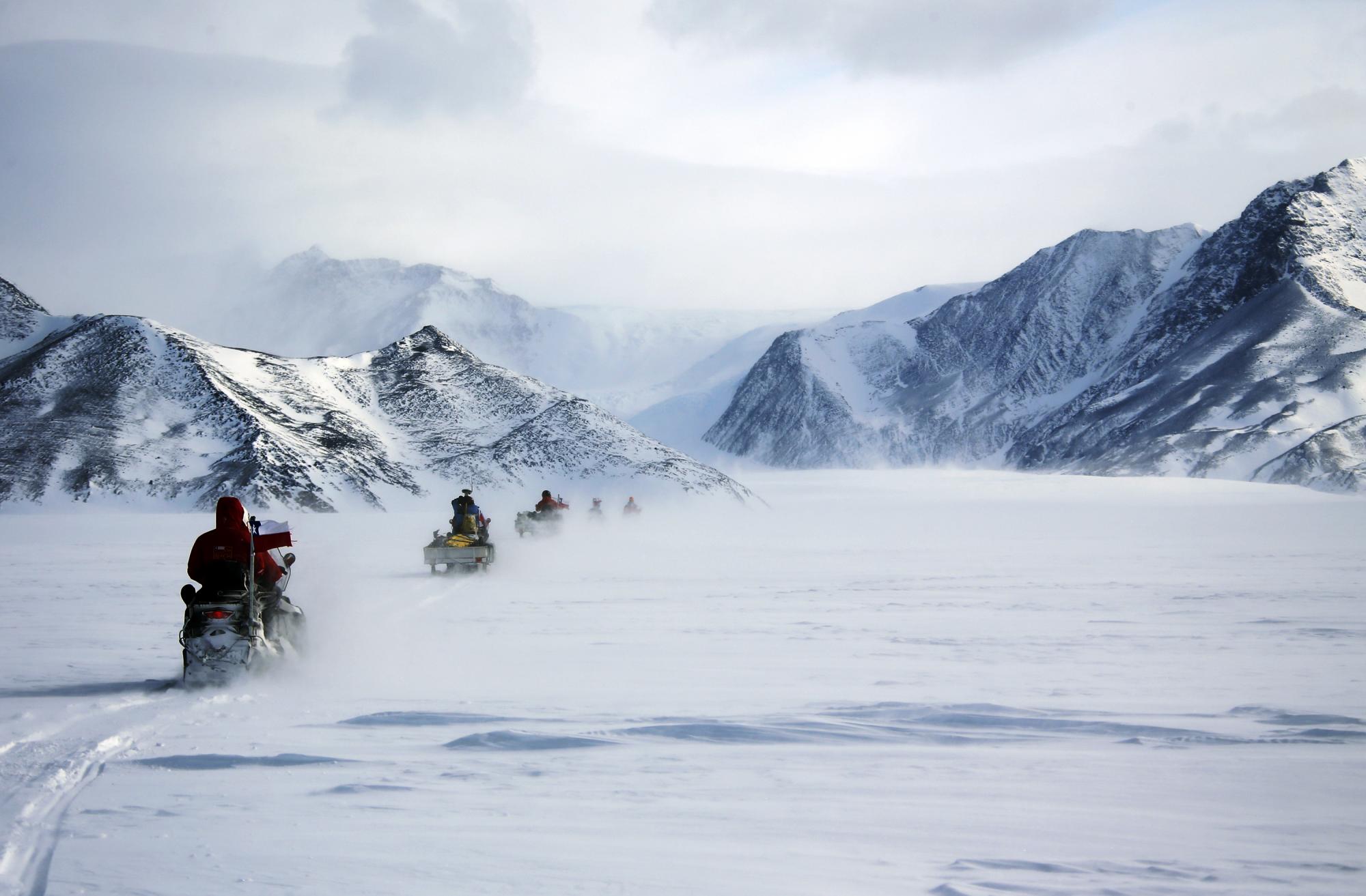 Fotografía del 2 de diciembre de 2015, que muestra a un grupo de científicos dirigiéndose en motos de nieve hacia Lester Peak durante una salida a terreno.