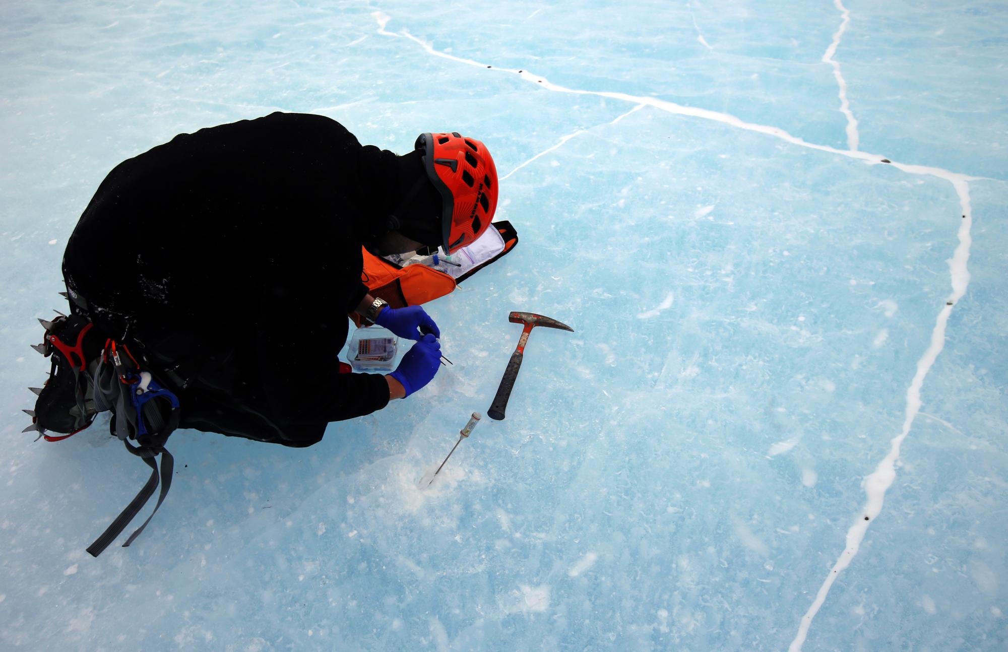 Fotografía del 23 de noviembre de 2015, que muestra a un científico tomando muestras de hielo en las inmediaciones de Charles Peak.