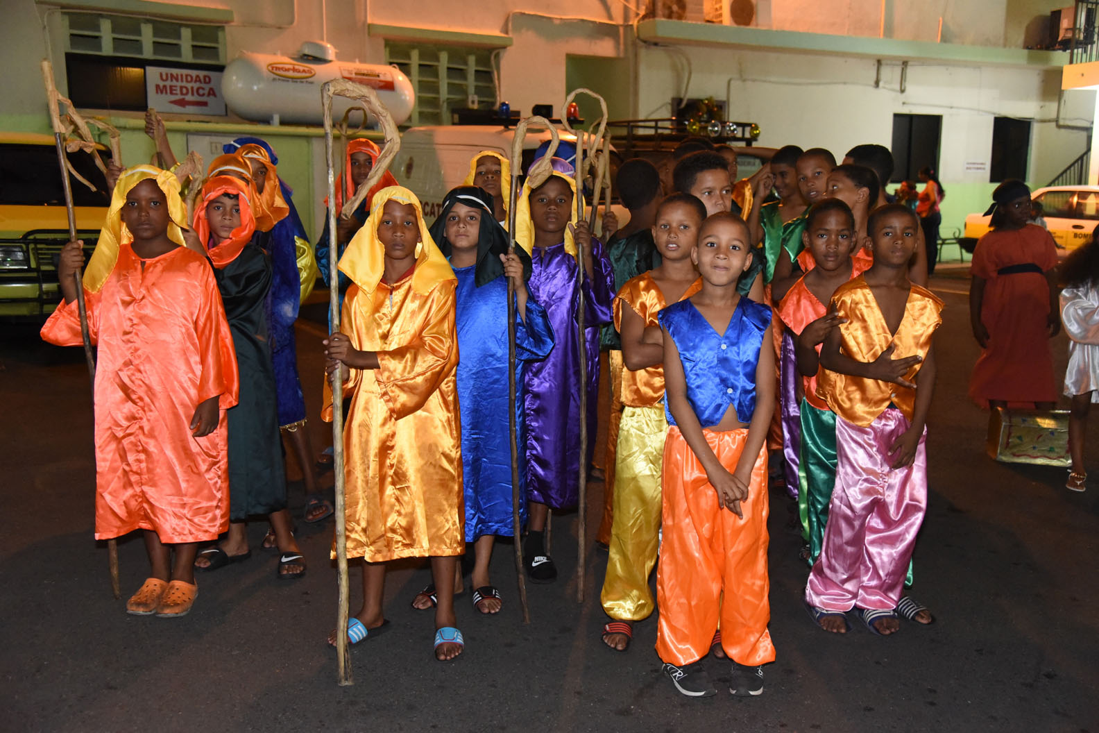Niños con bastones se preparan para salir al desfile.
