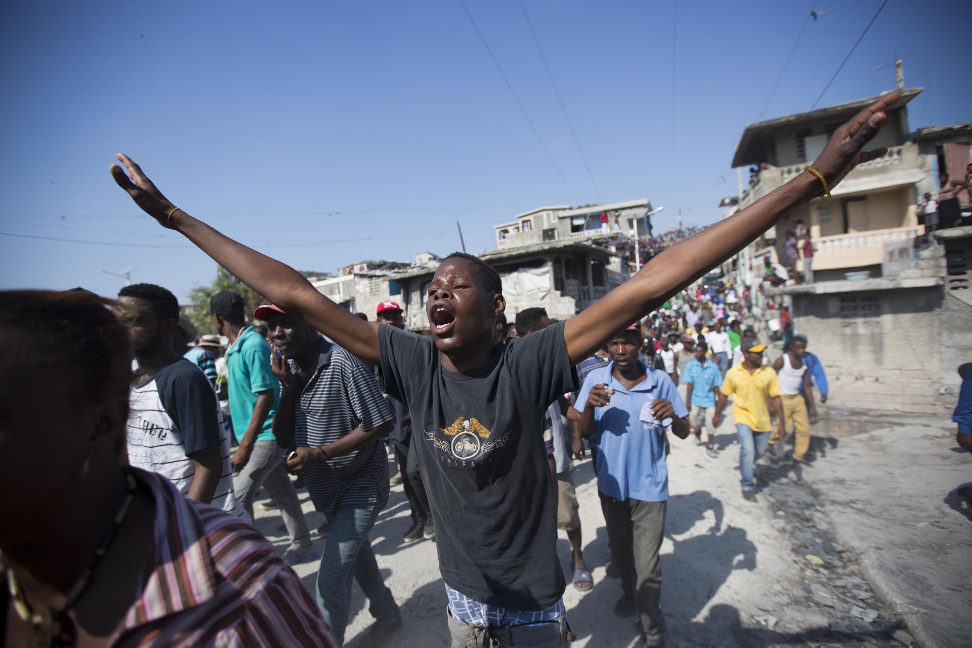 Un manifestante grita consignas contra el gobierno de Michel Martelly durante protesta.