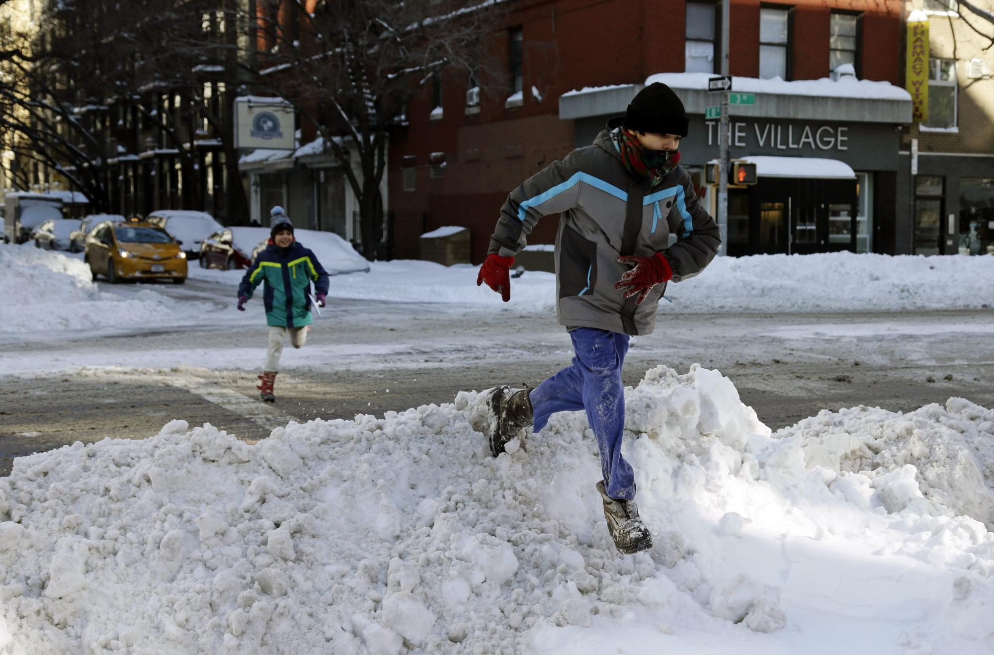 Un joven y un niño corren y juegan en la calle East Village, New York.