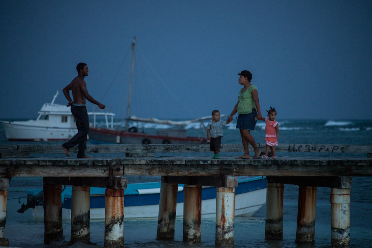 Una familia pasea por el unico muelle del pueblo.