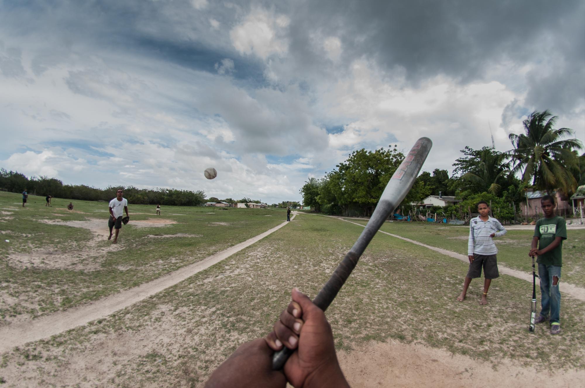 Unos niños juegan pelota en lo que pudiese llamarse play, el hombe queda en el centro de la única “calle del pueblo”.