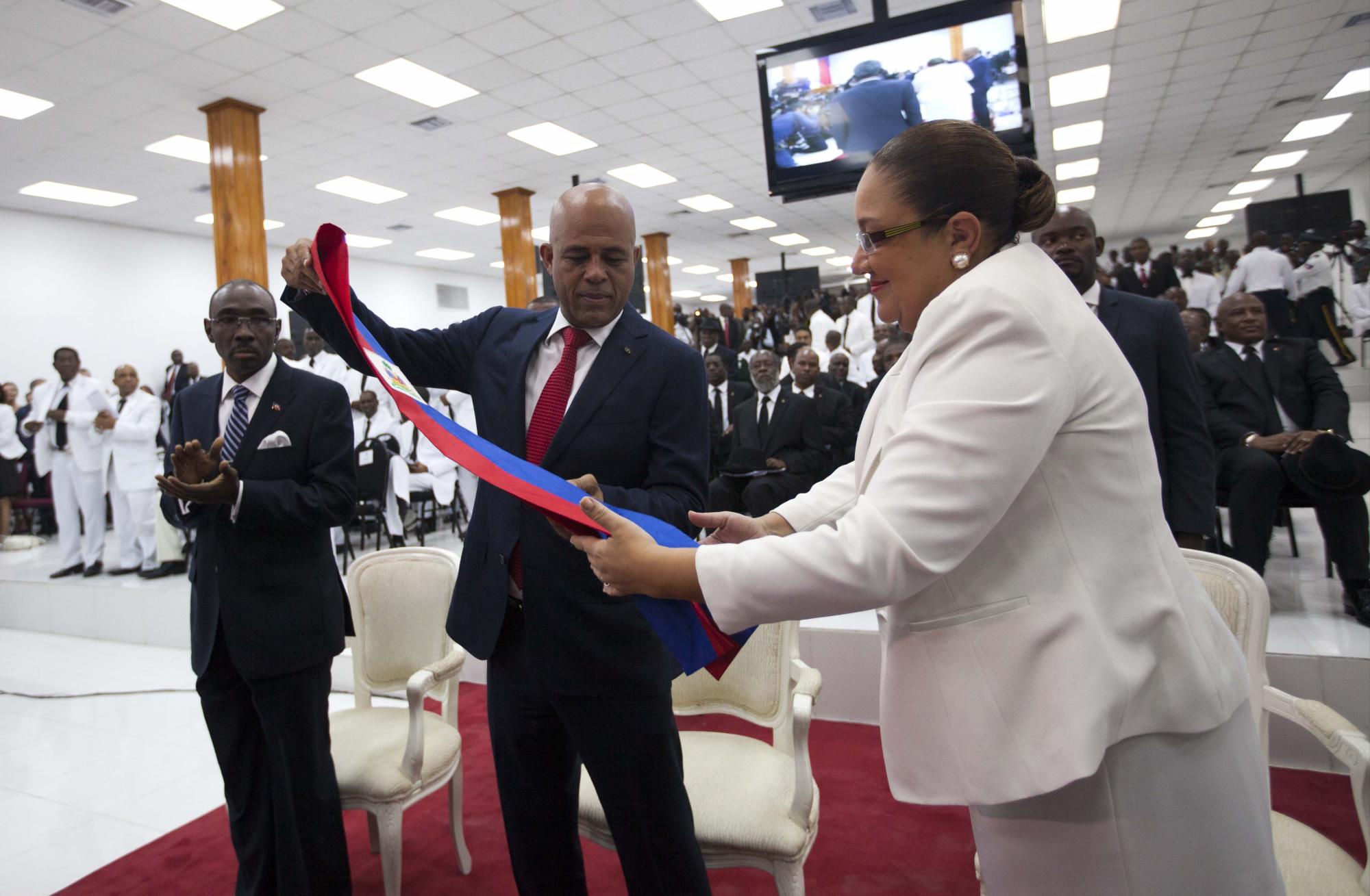 El presidente saliente de Haití, Michel Martelly, y su esposa Sophia doblan la banda presidencial de Haití después de que él pronunció su discurso de despedida en el Parlamento.