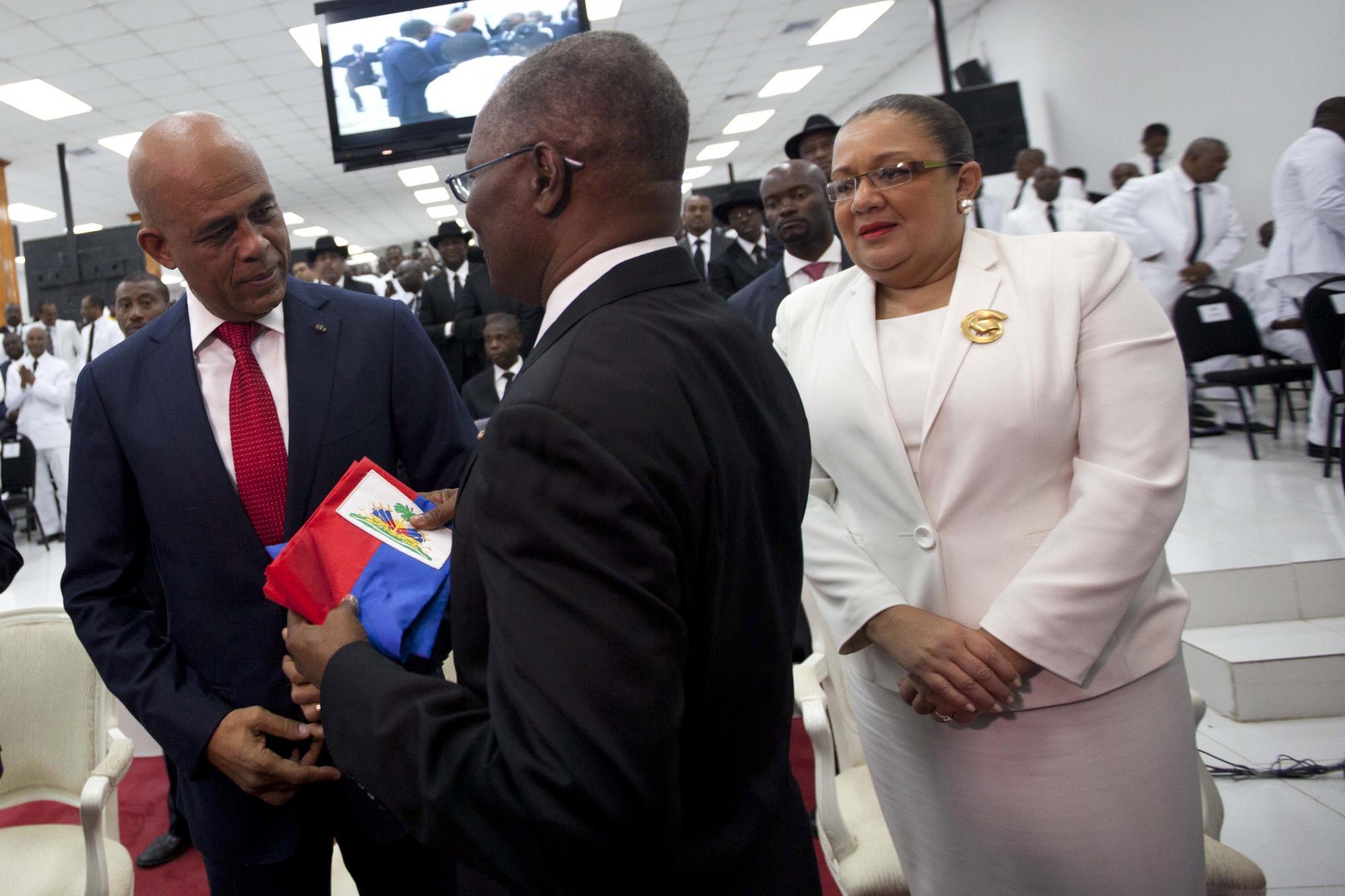 Martelly entrega la banda presidencial al presidente del Senado, Jocelerme Privert.